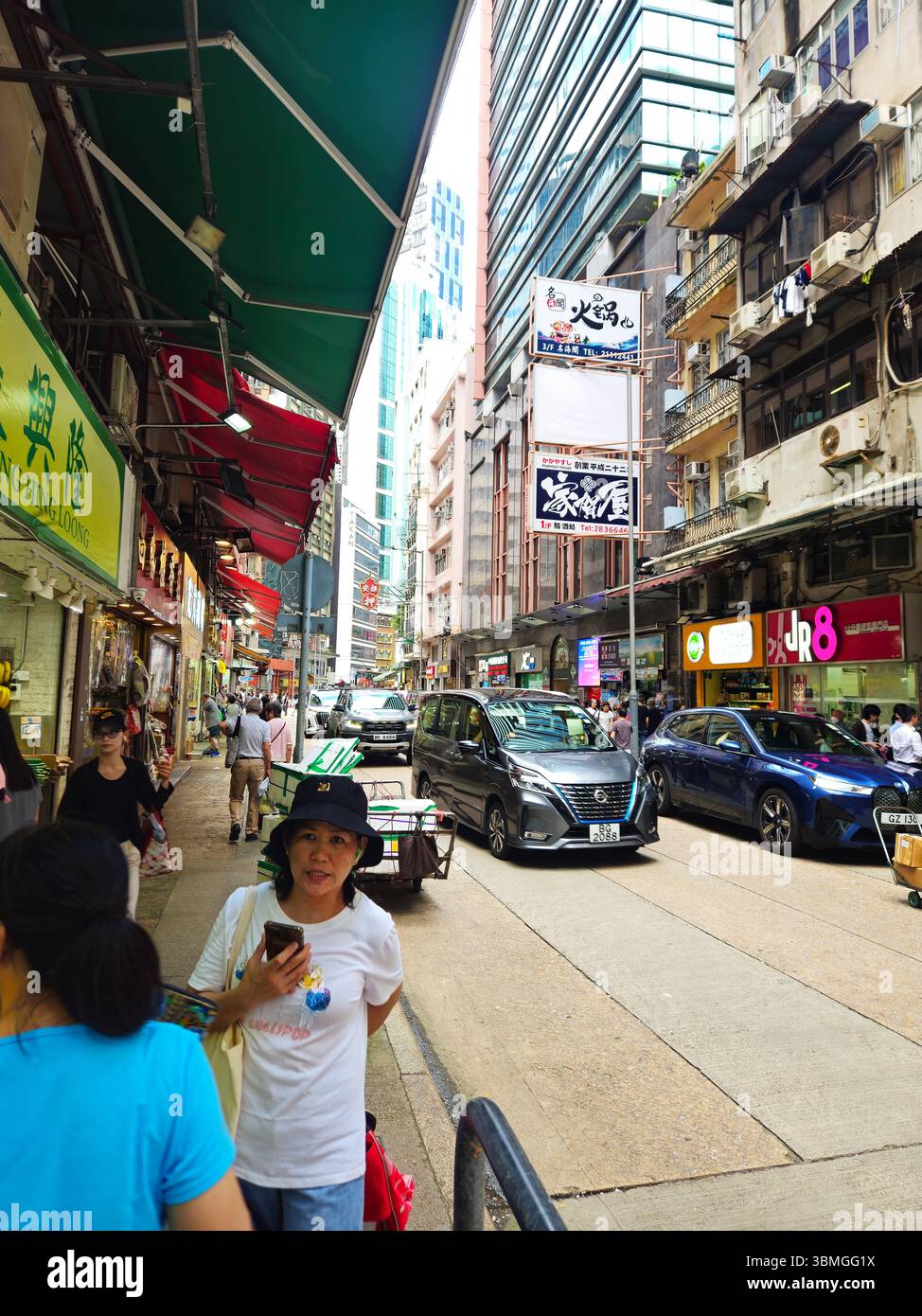 Vivace Hong Kong Urban Street con pedoni e traffico Foto Stock
