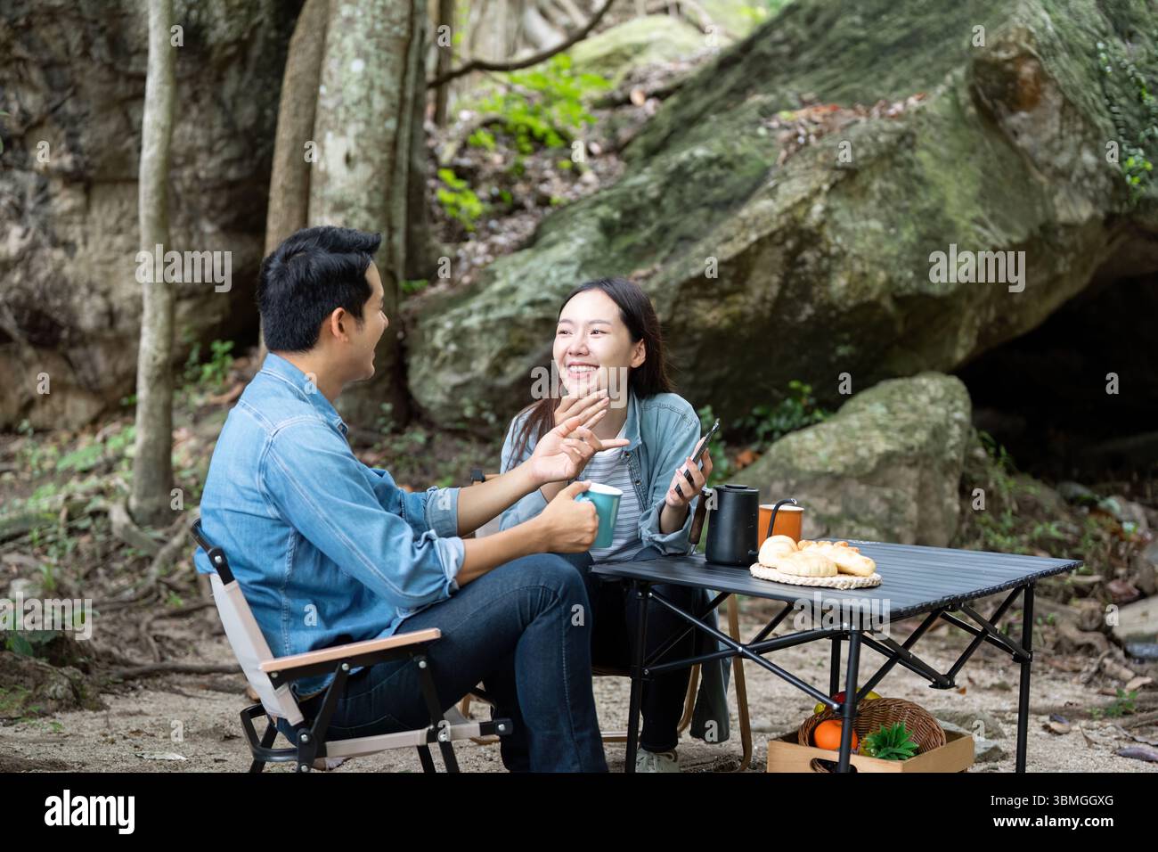 Coppia che ride e condivide momenti al Camping Site Foto Stock