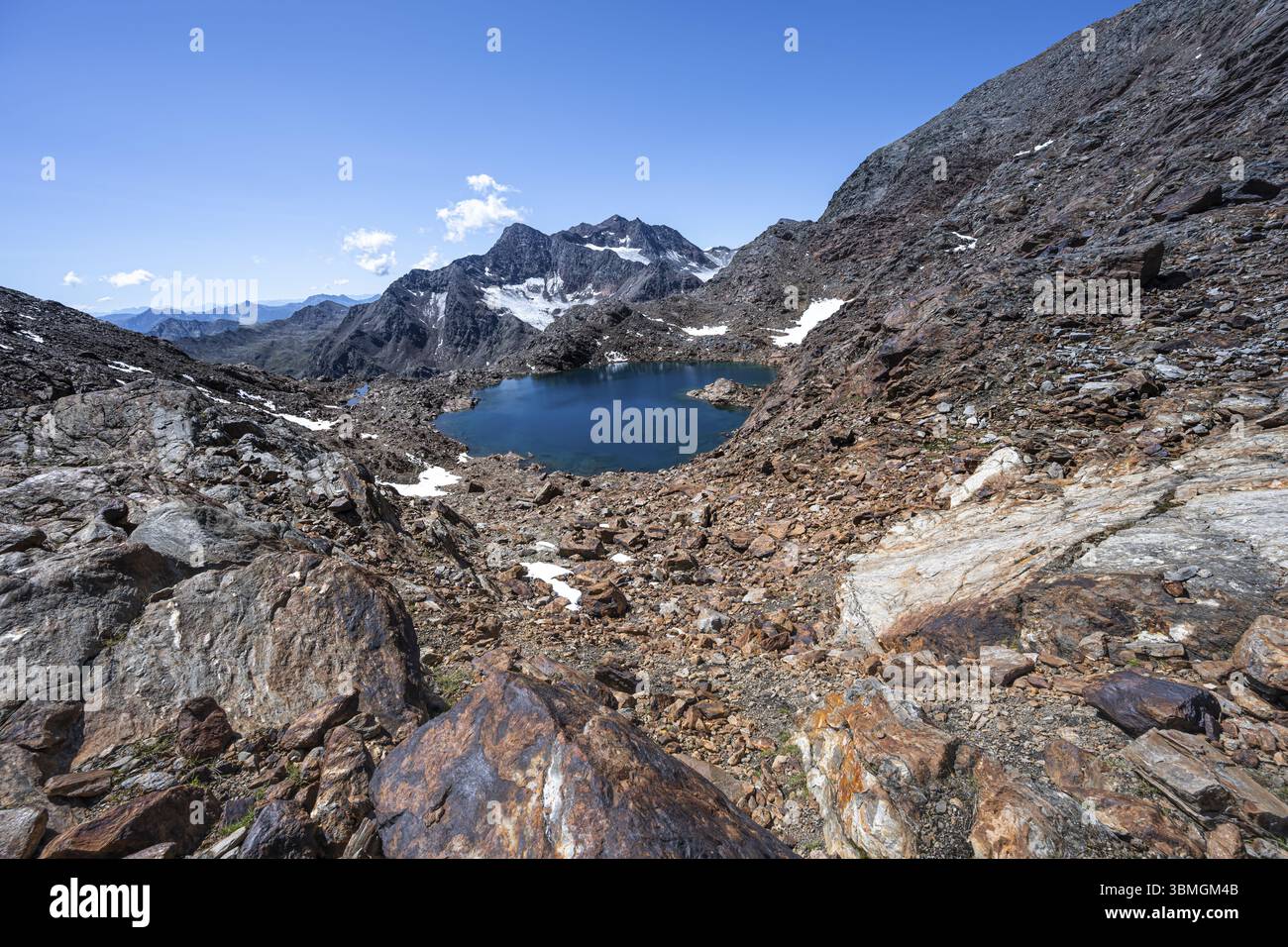 Lago glaciale blu in un paesaggio roccioso di montagna, Koenigshofspitz sullo sfondo, discesa dalla cima del Roter Grat, Alpi dello Stubai, Tyro meridionale Foto Stock