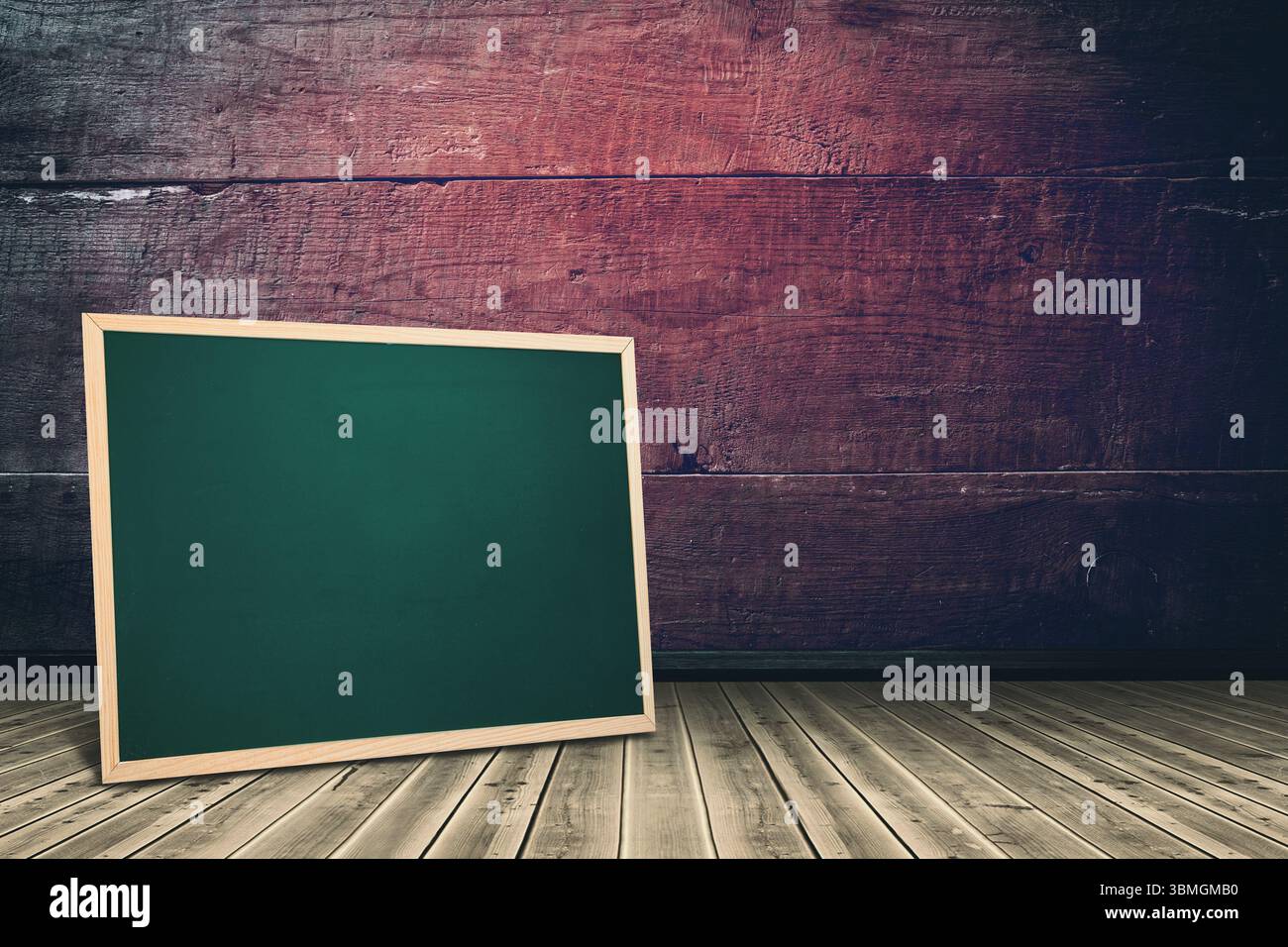 La lavagna verde dal design piatto si appoggia contro una parete rustica in legno con pavimento intemprato Foto Stock