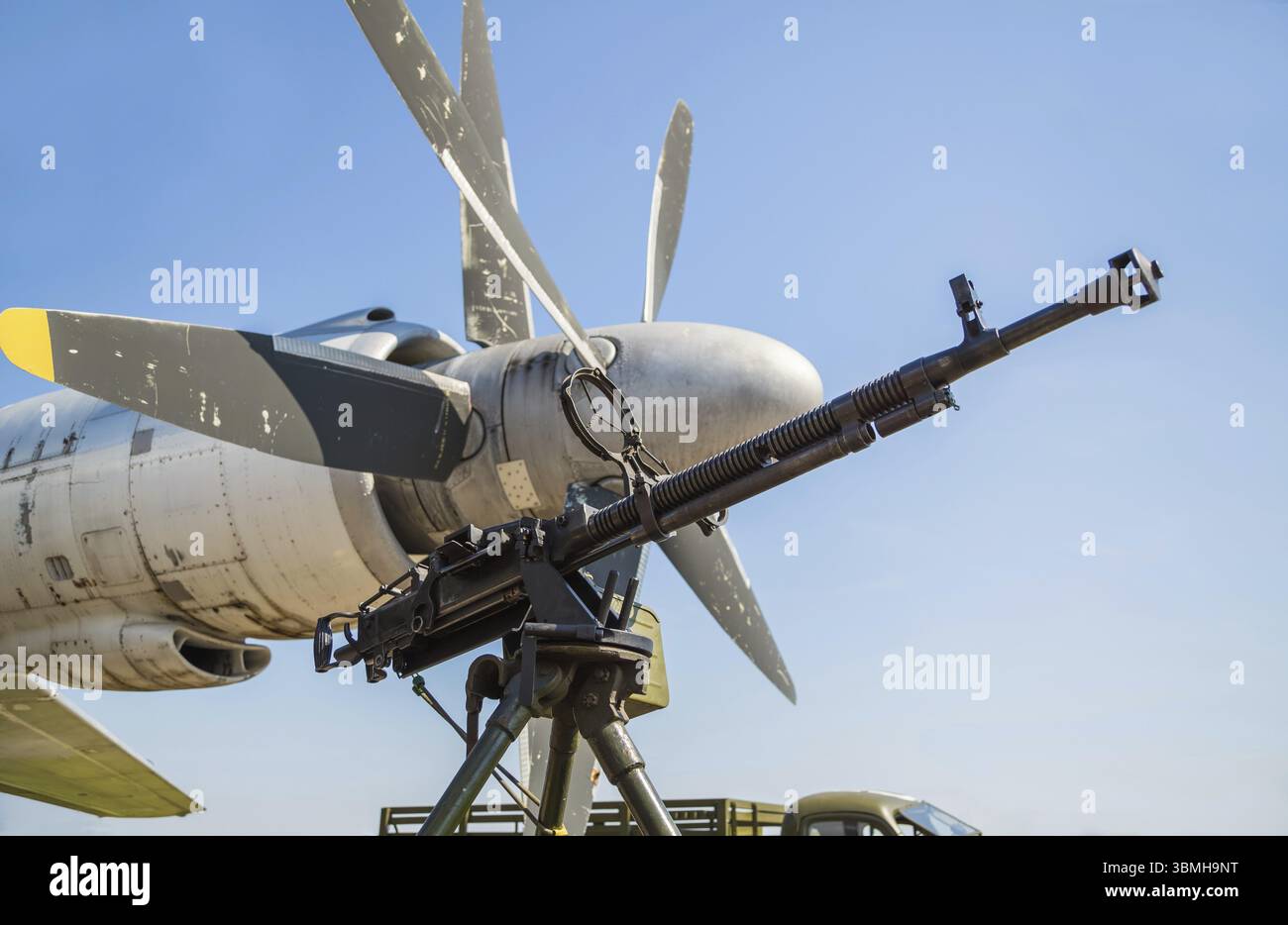 Pistola retrò sul treppiede e vista ottica, sullo sfondo delle eliche dell'aereo, primo piano. Mitragliatrice all'aperto Foto Stock