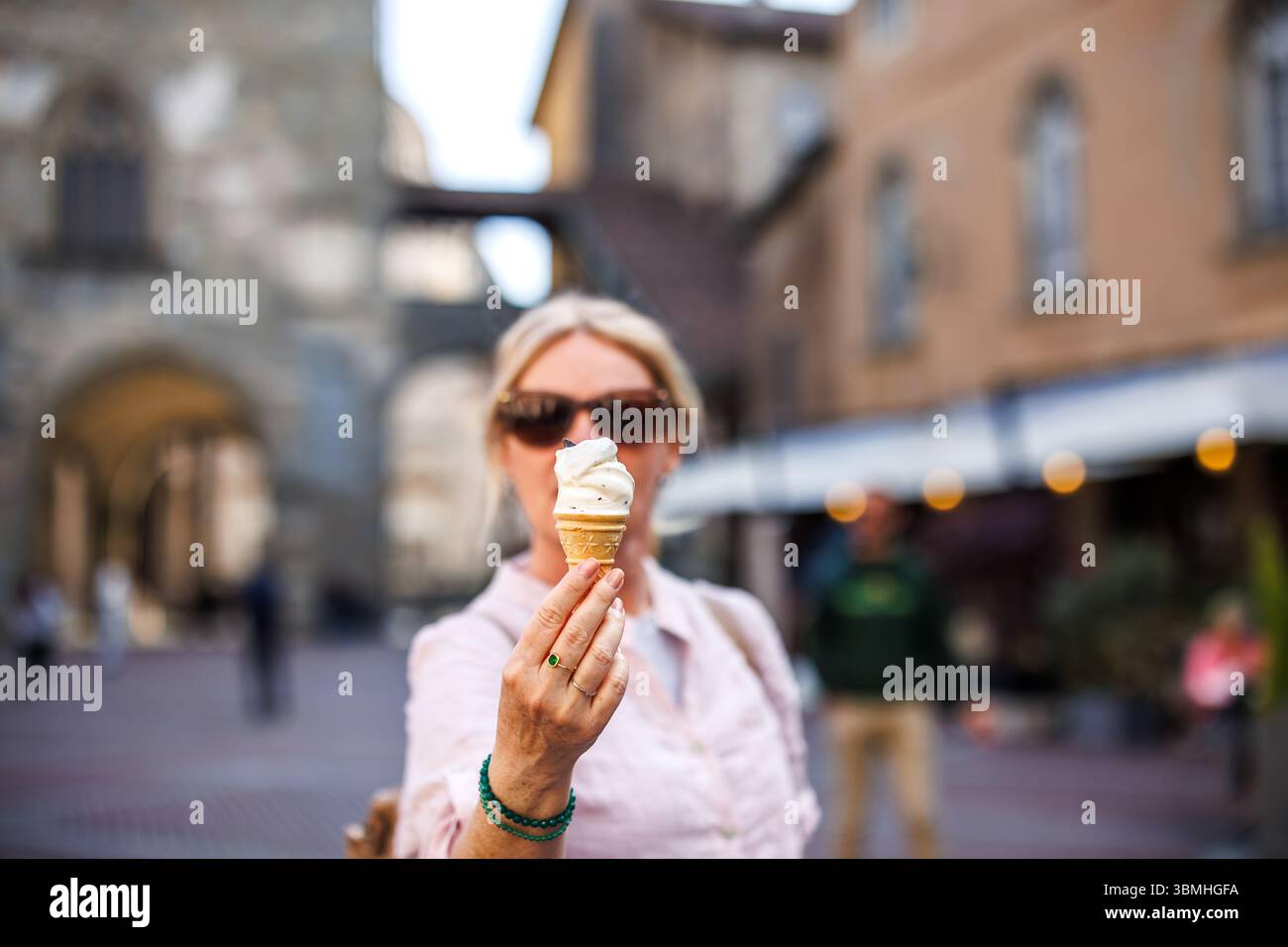 Turista donna che tiene il gelato tradizionale Stracciatella a Bergamo, in Italia, godendo delle vacanze estive e dello stile di vita italiano Foto Stock