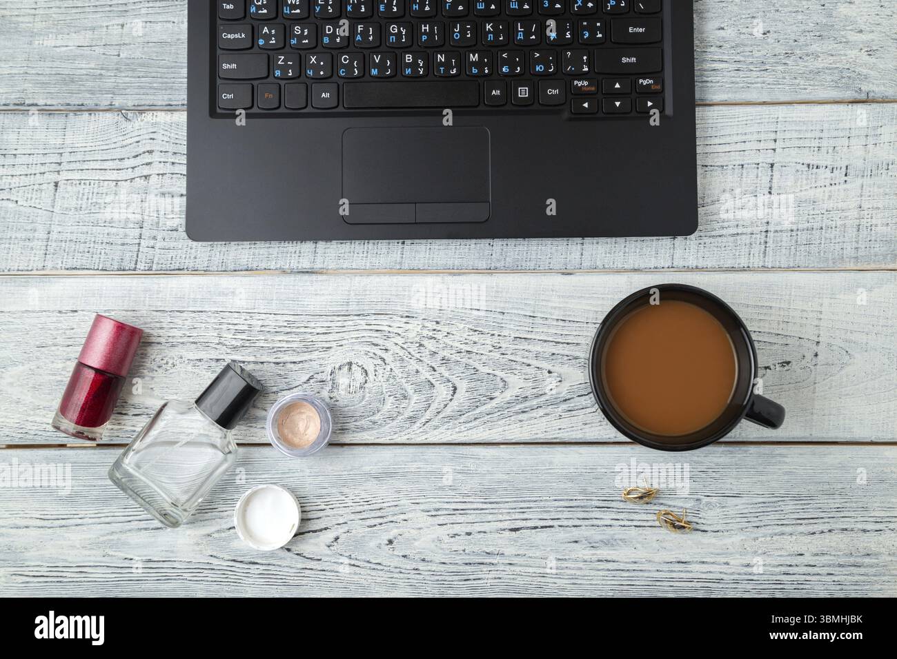 Scrivania. Posto di lavoro femminile.laptop, tazza di caffè profumata e cosmetici. la vista dall'alto. posizione piatta Foto Stock