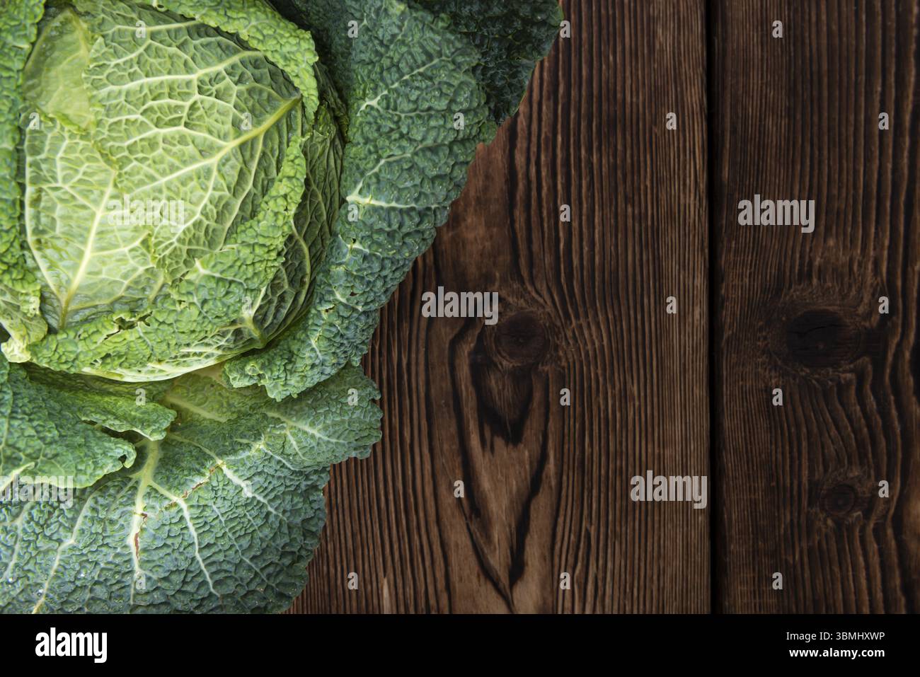 Porzione di fresh Savoy (close-up shot) su sfondo di legno Foto Stock