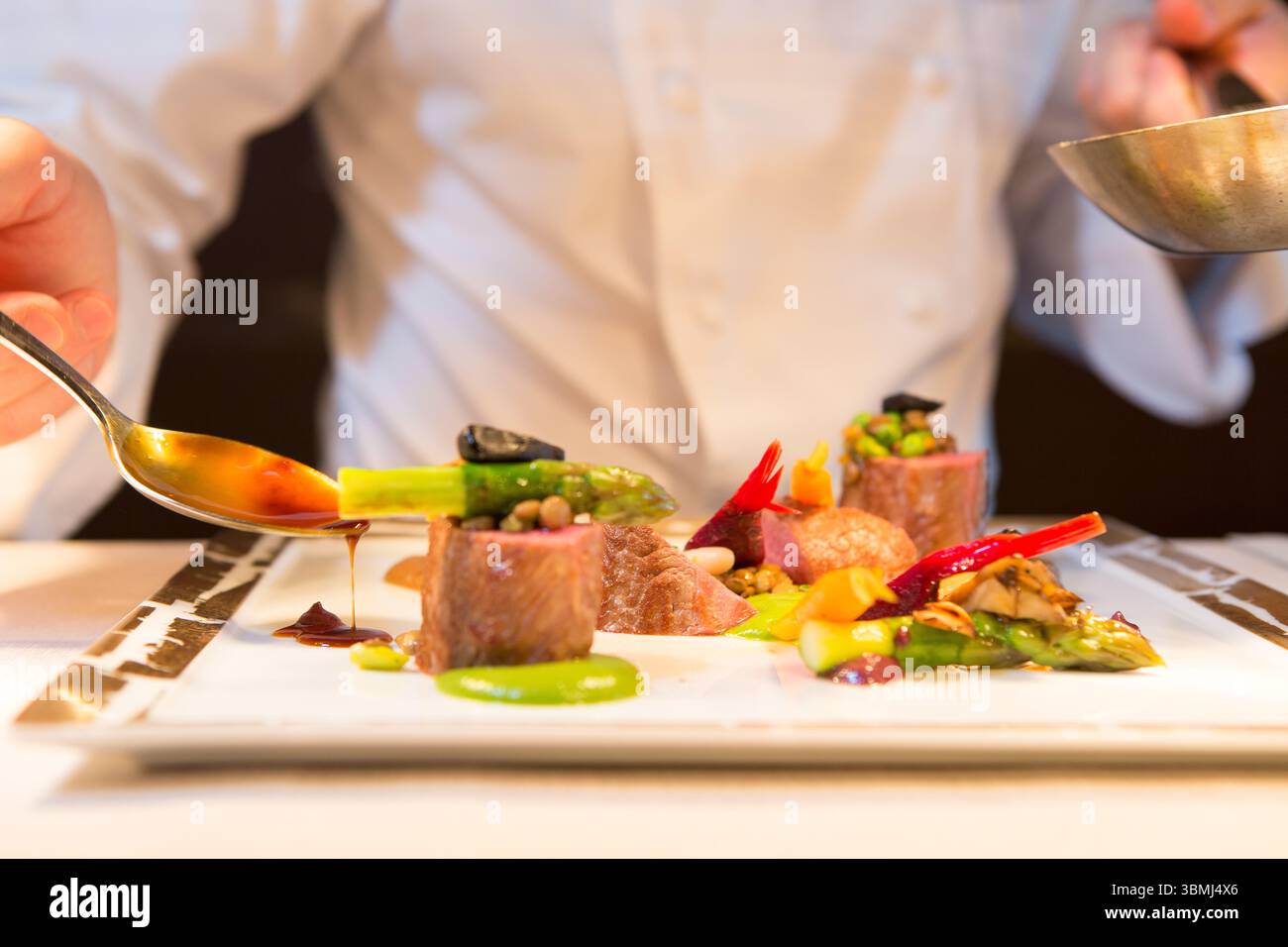 Uno chef semina sapientemente teneri filetti di manzo Foto Stock