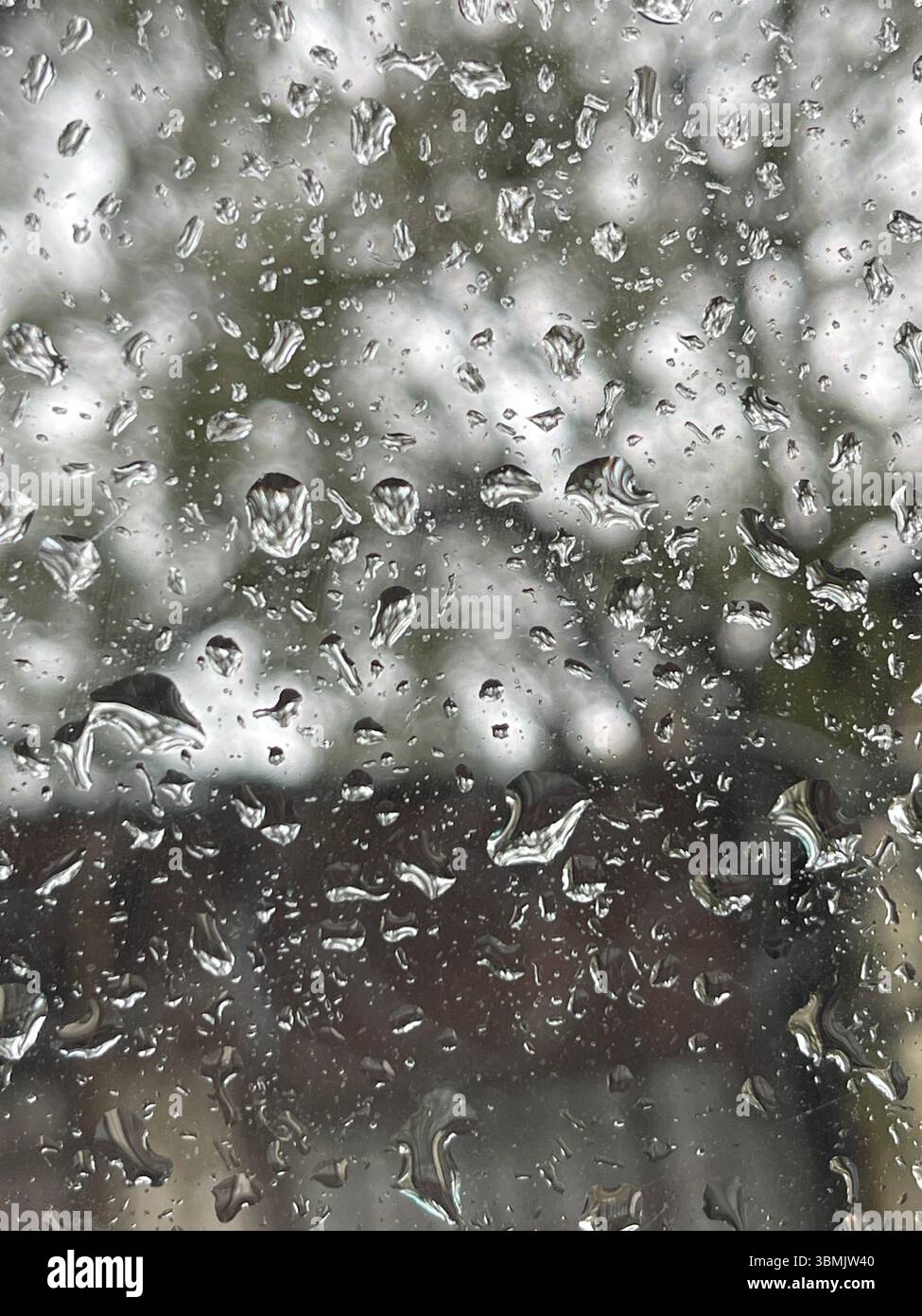 L'acqua cade su una finestra durante il freddo inverno. Foto Stock