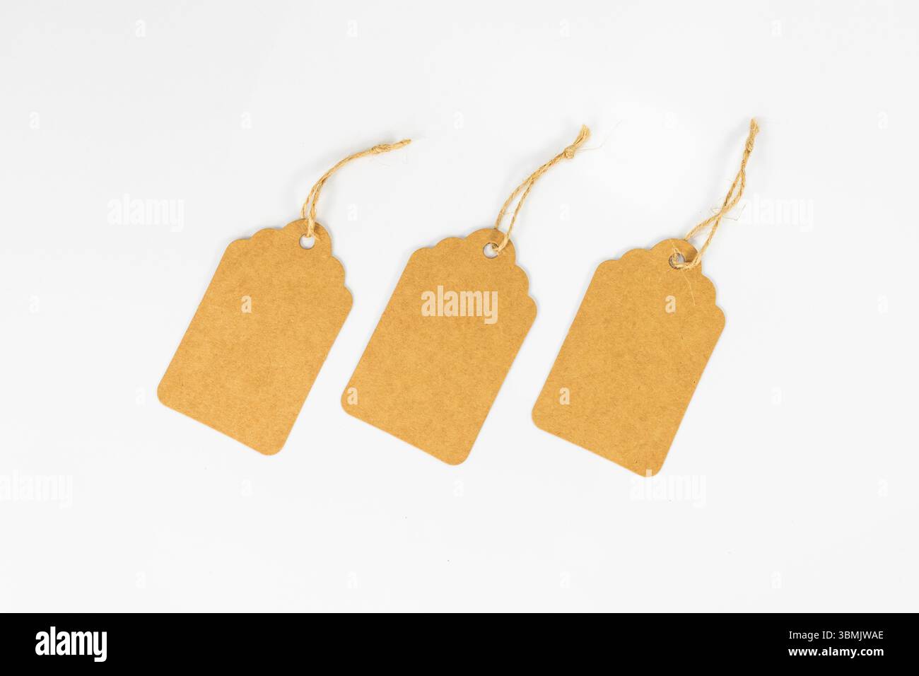 Set di tre etichette in carta kraft vuote con spago su sfondo bianco Foto Stock