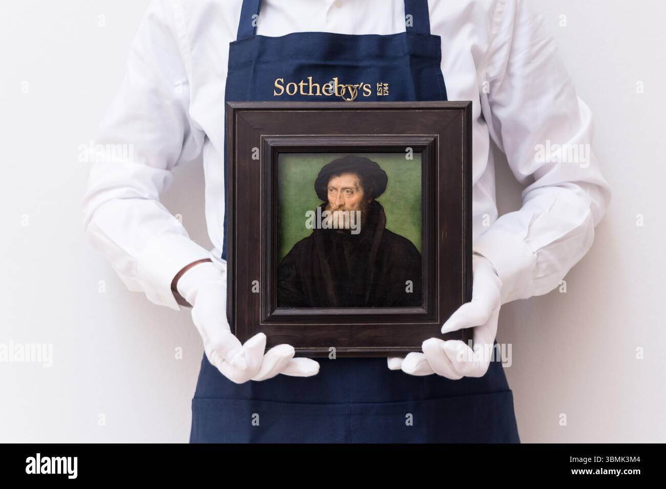 LONDRA, REGNO UNITO - 27 GIUGNO 2025: Un gestore d'arte tiene un dipinto intitolato "Ritratto di un mercante, tradizionalmente identificato come Theodore Beza (1519-1605)" da Corneille de Lyon, stima: £ 300.000 - 400.000 durante una chiamata fotografica alla casa d'asta di Sotheby prima della vendita di Old Masters a Londra, Regno Unito il 27 giugno 2025. (Foto di Wiktor Szymanowicz/NurPhoto) Foto Stock