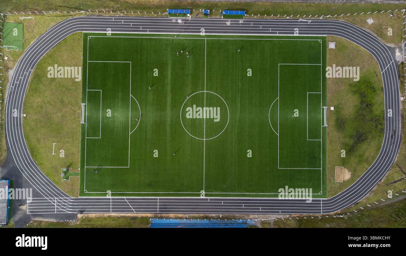 Vista aerea dall'angolo Zenith/nadir giù di un campo da calcio in una giornata di sole, dove spicca il colore verde dell'erba. Foto Stock