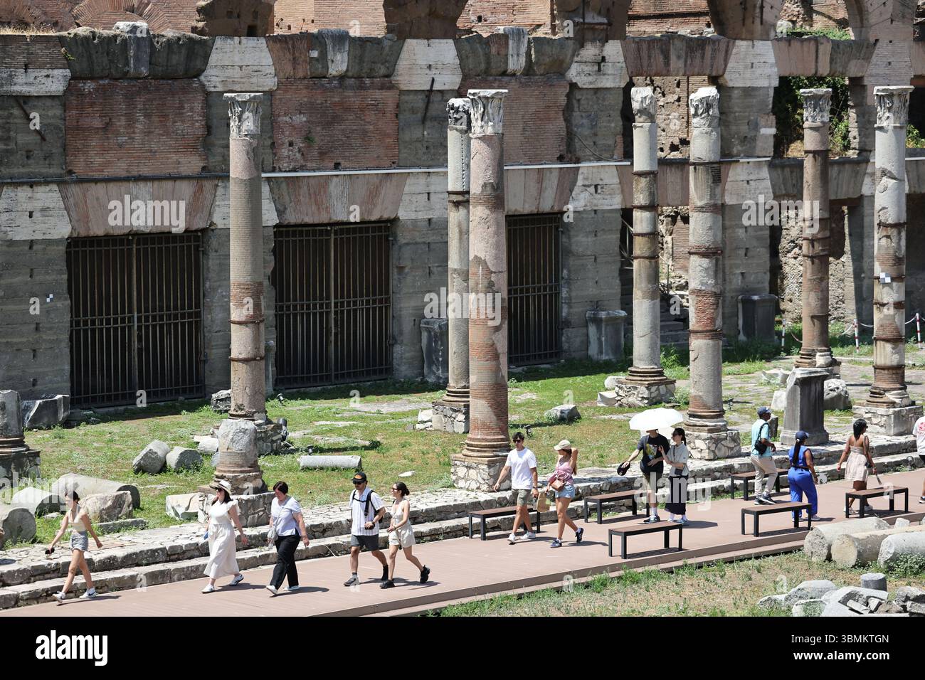 Roma, Italia. 27 giugno 2025. I turisti camminano nell'ondata di caldo ai fori Imperiali di Roma, Italia, 27 giugno 2025. Il Ministero della Sanità italiano ha emesso avvisi di calore rossi consecutivi per decine di grandi città in tutto il paese, a partire da giugno 27 e proseguendo per tutto il fine settimana. Crediti: Li Jing/Xinhua/Alamy Live News Foto Stock