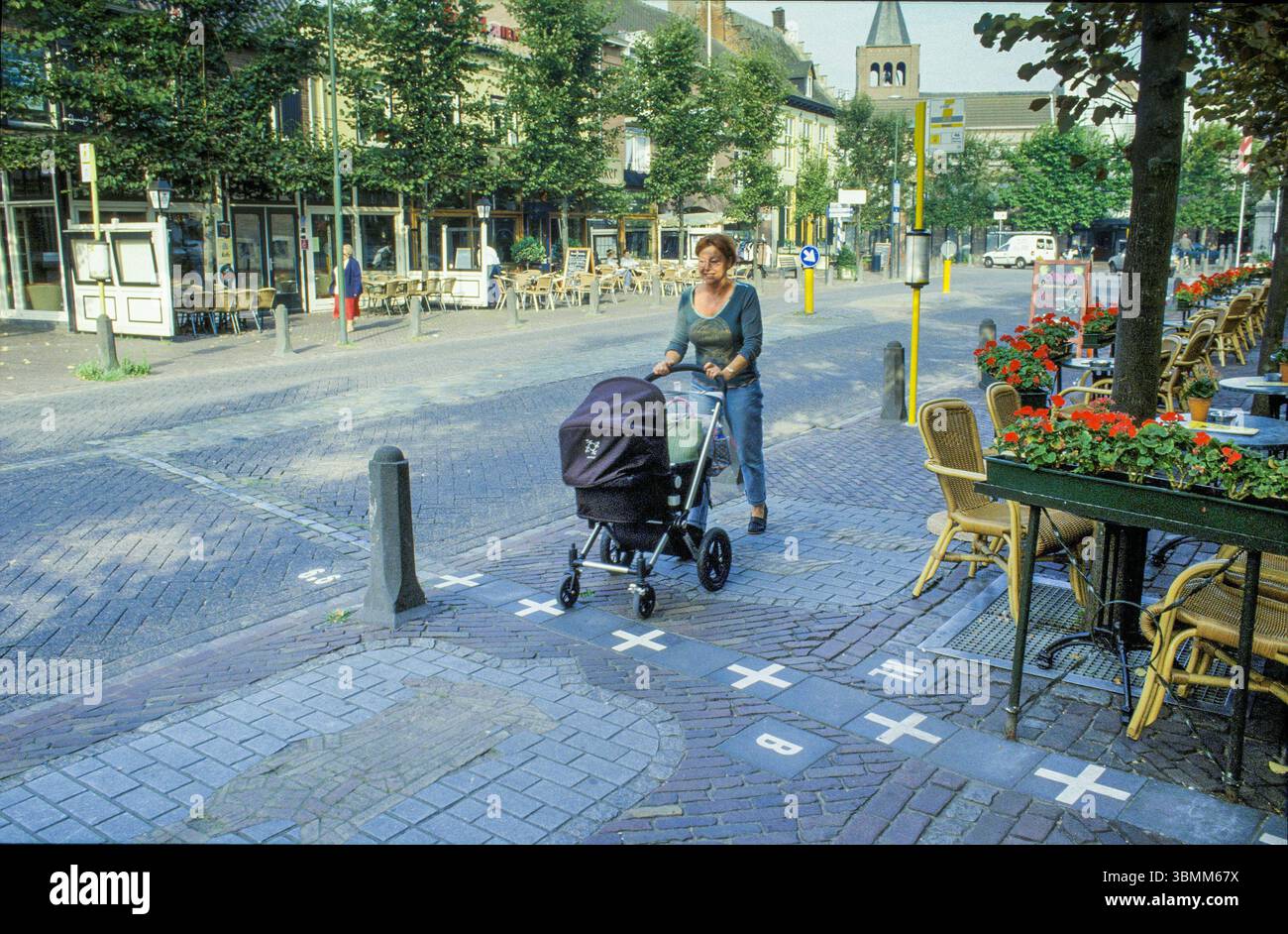 Una donna con un bambino sta attraversando il confine tra i Paesi Bassi e il Belgio a Baarle Nassau. Foto Stock