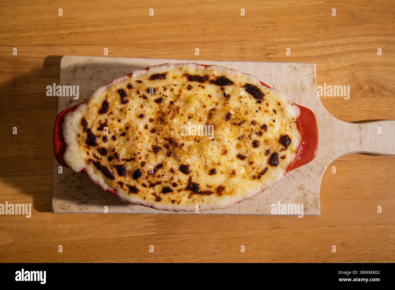 Formaggio macaroni appena sfornato in un piatto arancione da forno, top croccante dorato direttamente dal forno Foto Stock