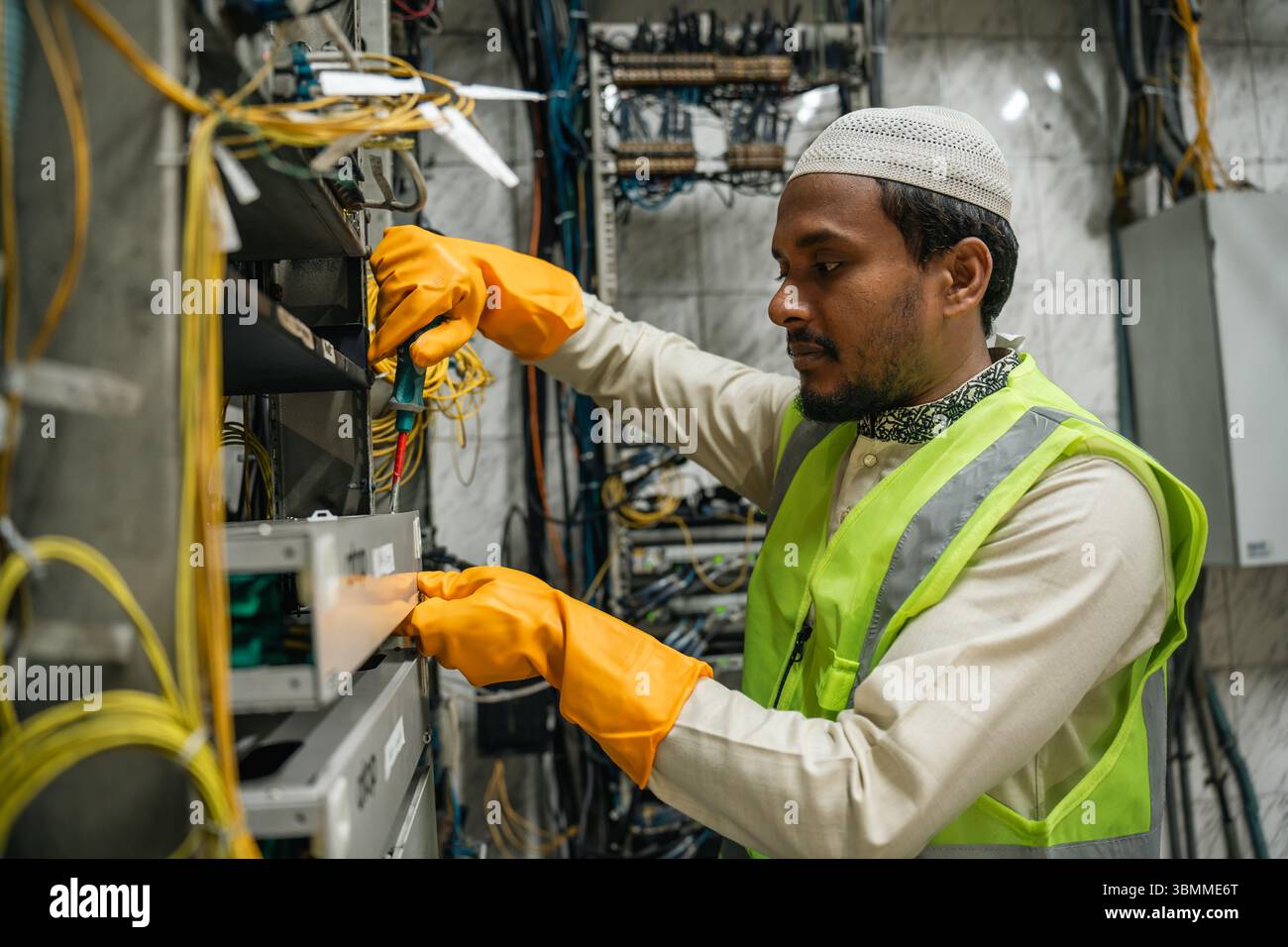 Tecnici e tecnici addetti alla riparazione di dispositivi di rete, router, configurazione dei server e riparazione dei cavi nella sala di rete. Manutenzione IT Foto Stock