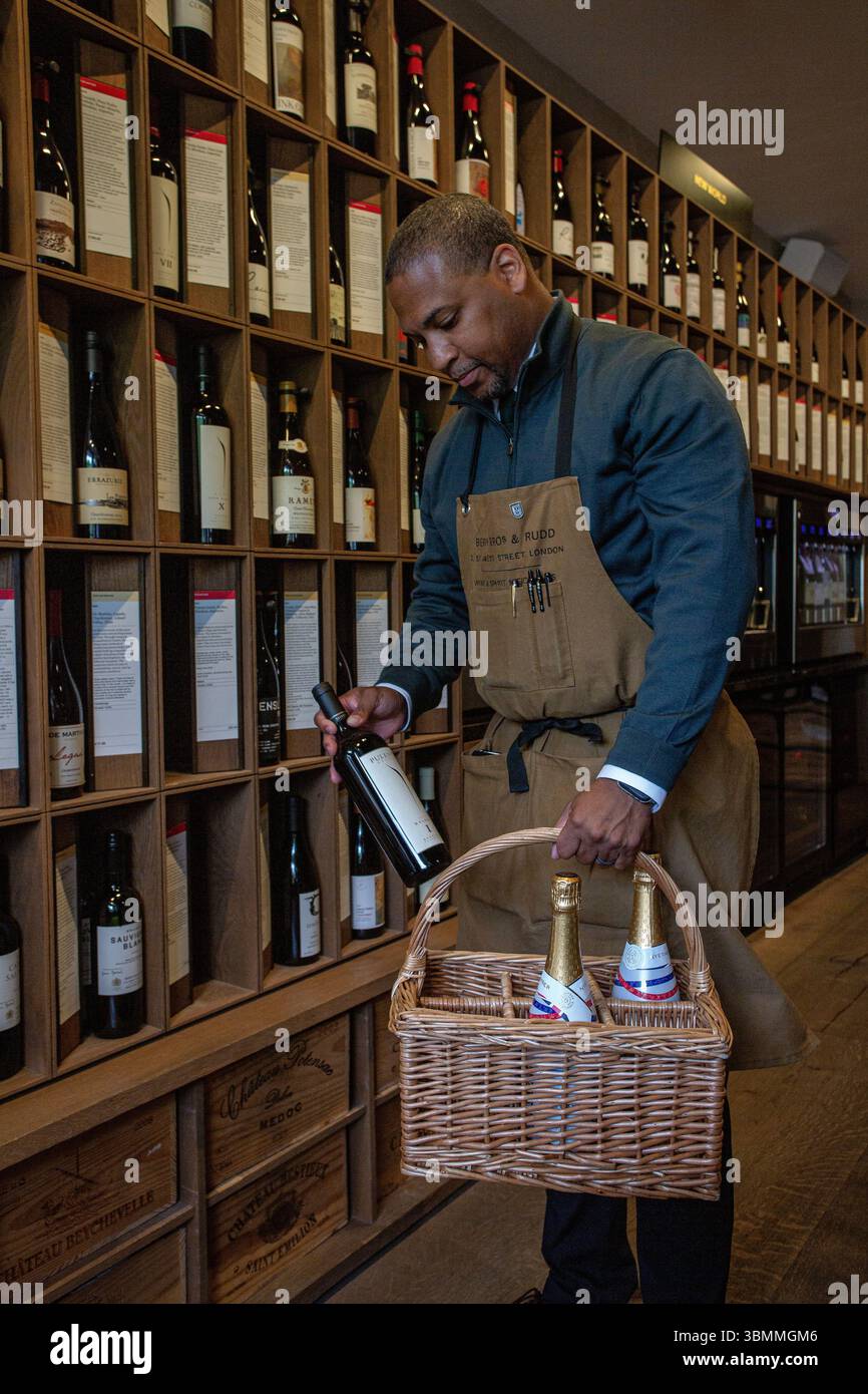 Assistente di negozio al Berry Bros. & Rudd, che seleziona e confeziona con cura il vino, mescolando il servizio storico con il moderno commercio al dettaglio. Foto Stock Assistente di negozio al Berry Bros. & Rudd, che seleziona e confeziona con cura il vino, mescolando il servizio storico con il moderno commercio al dettaglio. Foto Stock