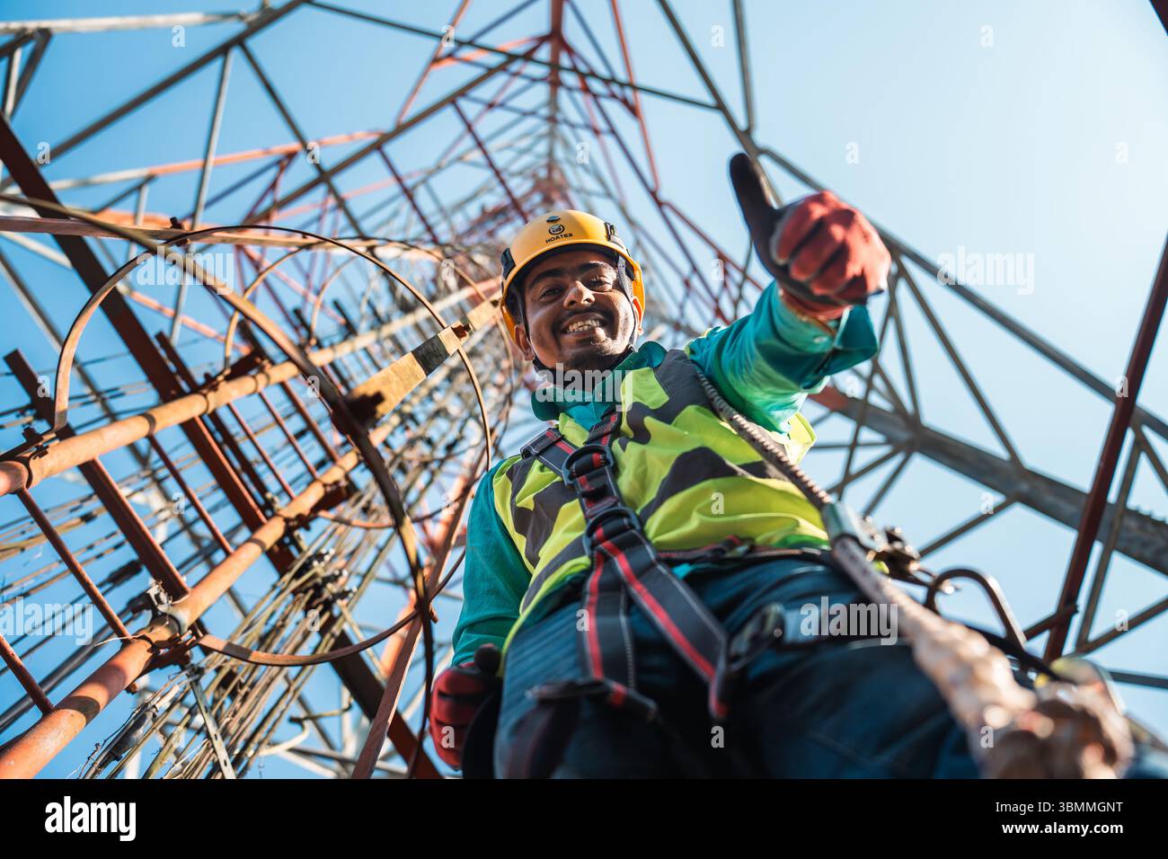 Tecnici che si arrampicano su una torre di rete con dispositivi di sicurezza, risoluzione dei problemi relativi alla torre di rete mobile, torre di telefonia mobile, antenna radio, rete wireless Foto Stock