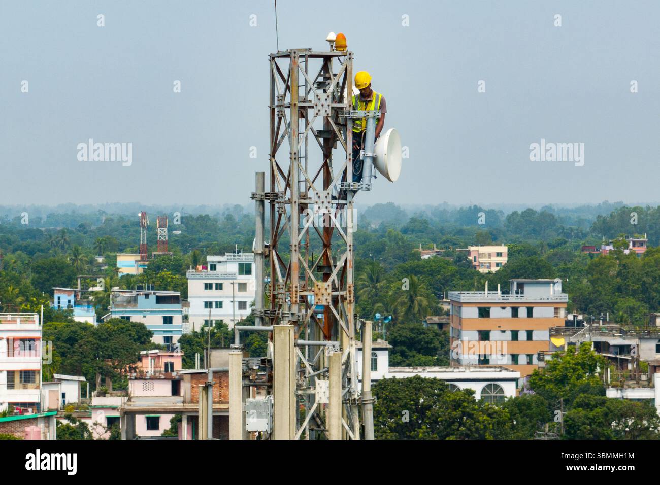 Tecnici che si arrampicano su una torre di rete con dispositivi di sicurezza, risoluzione dei problemi relativi alla torre di rete mobile, torre di telefonia mobile, antenna radio, rete wireless Foto Stock