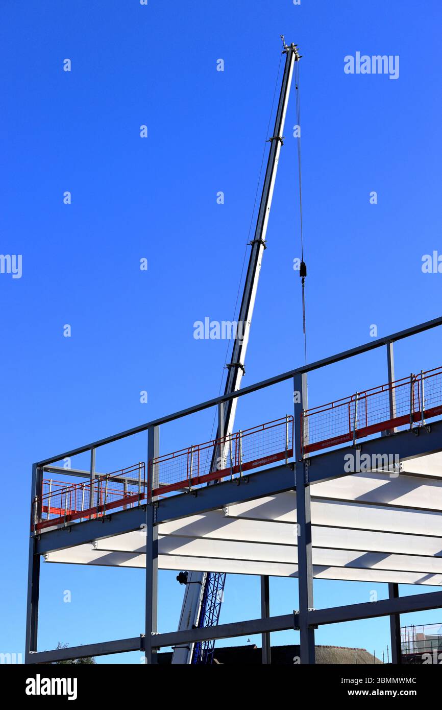 Telaio in acciaio con struttura a scheletro in acciaio e braccio telescopico con gru mobile sullo sfondo presso il sito di sviluppo del mozzo radcliffe a radcliffe, seppellito, grande mancheste Foto Stock