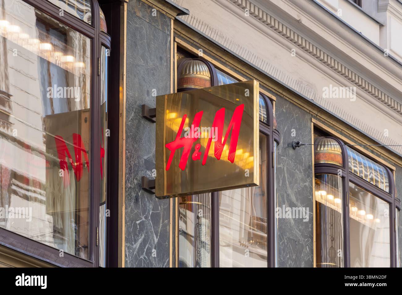 Il moderno logo H&M sulla facciata dell'edificio con una finitura lucida. Un marchio di moda veloce sullo sfondo dell'architettura urbana. Austria, Vien Foto Stock
