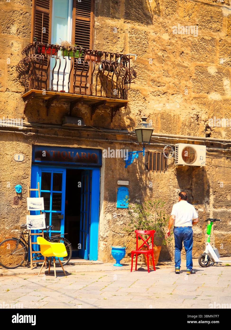 Negozio di antiquariato di Palermo con sedie colorate e facciata rustica Foto Stock
