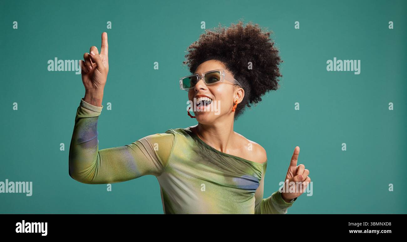 Punta, danza e donna africana in studio con moda, energia e mosse per festeggiare. Persona felice, eccitata e gesto per il groove, occhiali da sole Foto Stock