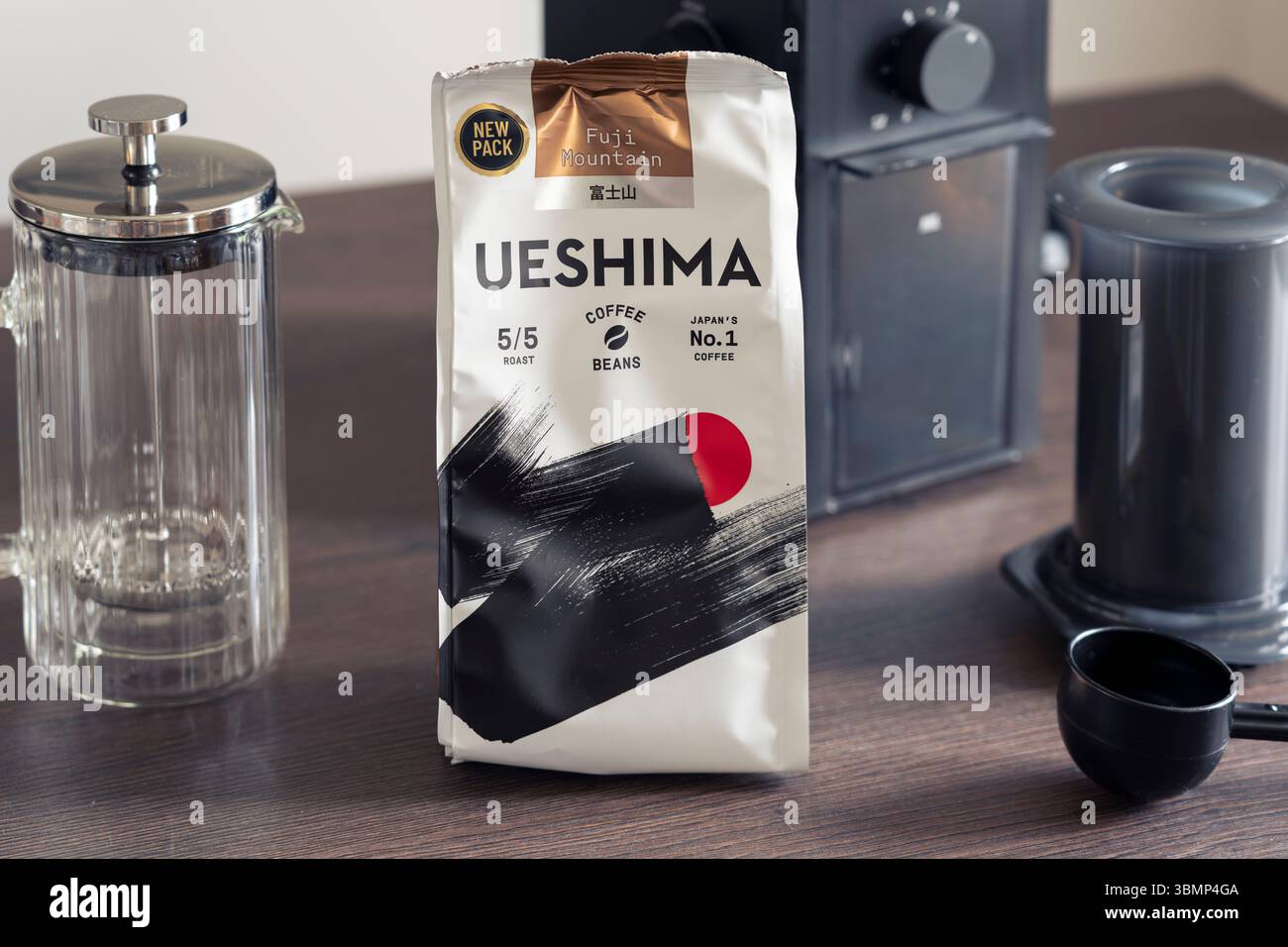 Pacchetto di chicchi di caffè tostato scuro di Fuji Mountain Ueshima su una superficie della cucina con attrezzatura per la preparazione del caffè, dichiarato come il marchio di caffè numero uno del Giappone Foto Stock