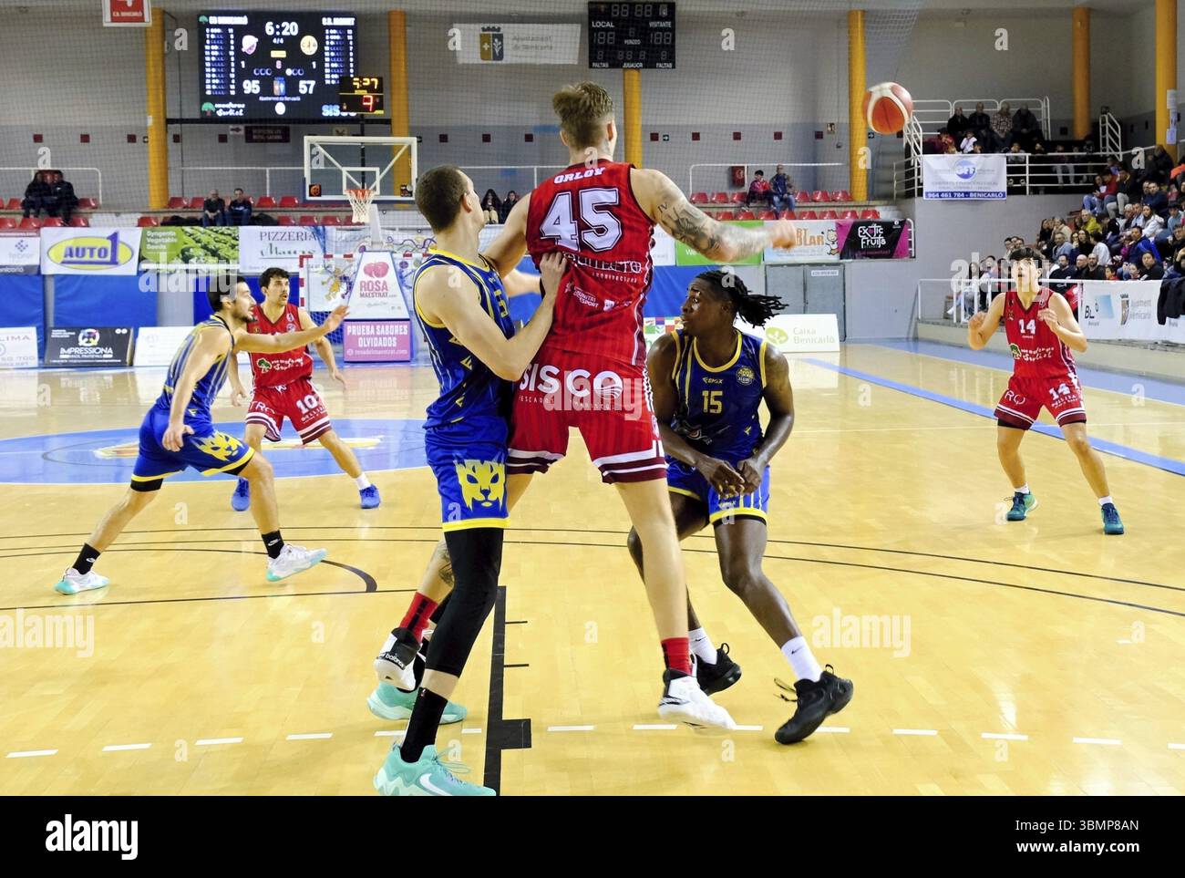 Intenso momento di gioco del basket con i giocatori che saltano e si avvicinano alla palla Foto Stock