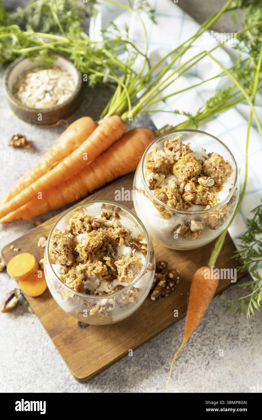Cottura vegana senza glutine. Torta di carote con noci e cannella in un bicchiere su sfondo chiaro. Dessert sano Foto Stock