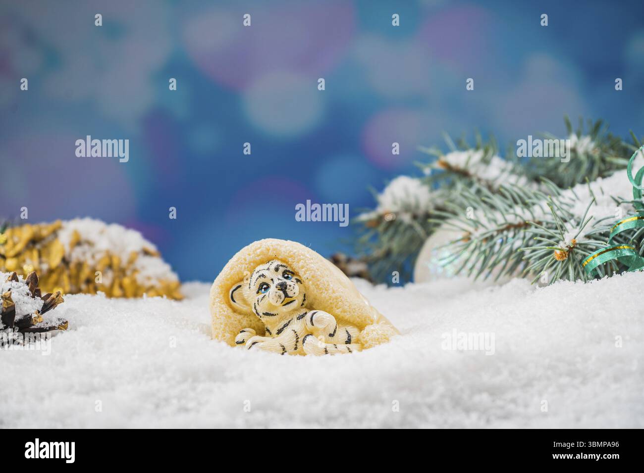 Giocattolo di cioccolato natalizio sulla neve. Giocattolo al cioccolato a forma di tigre, simbolo dell'anno 2022. Umore gioioso Foto Stock