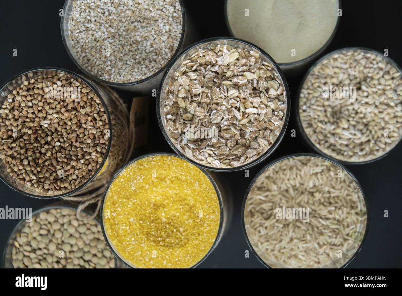 Vaso in vetro ricaricabile con porridge a grana cruda. Spazio di copia ricarica formato prodotto ecologico. Riempimento del contenitore riutilizzabile degli speci di grana intera Foto Stock