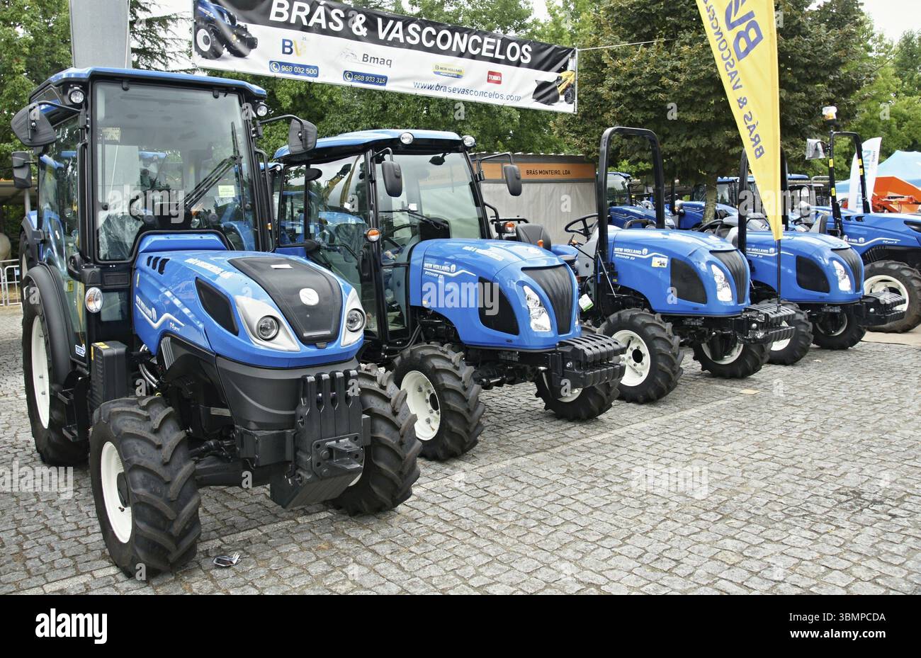 Trattori New Holland di colore blu lucido parcheggiati, con macchinari e tecnologie agricole moderne Foto Stock