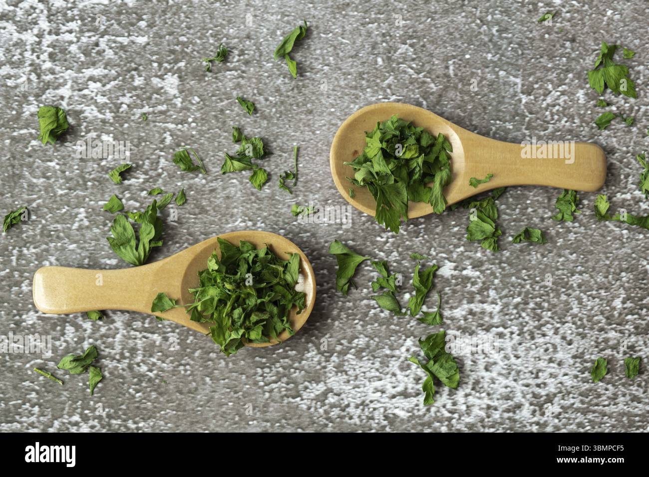 Cucchiaio di legno con prezzemolo verde secco. Vegetariano bio insalata biologica erba mangiare sano. Casa giardino immunità-Boosting erbe. Raccolto stagionale cottageco Foto Stock