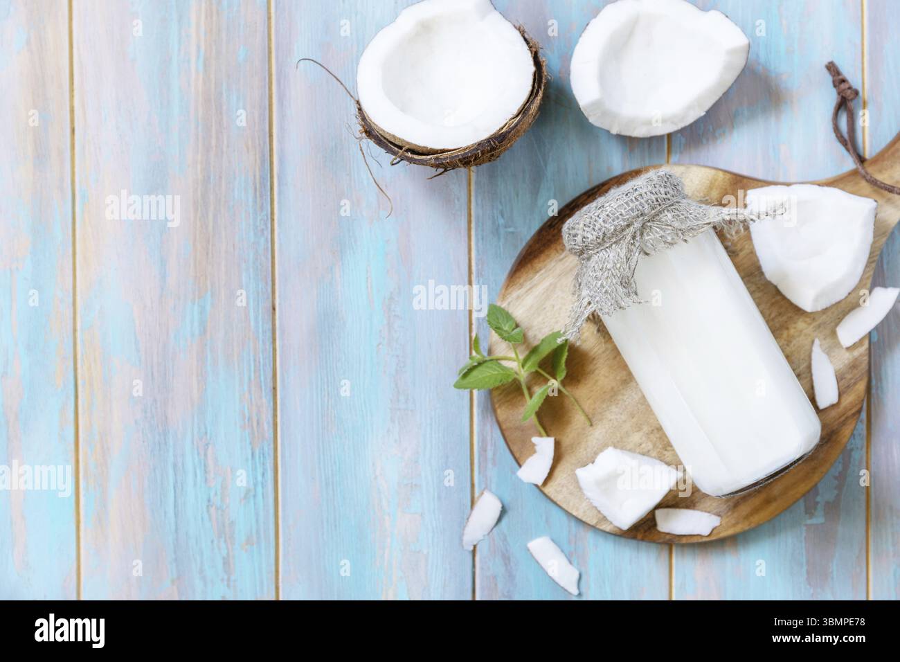 Vegan latte alternativo non lattiero-caseario, contenuto di salute. Latte di cocco biologico in un biberon su un tavolo rustico. Vista dall'alto. Copia spazio Foto Stock