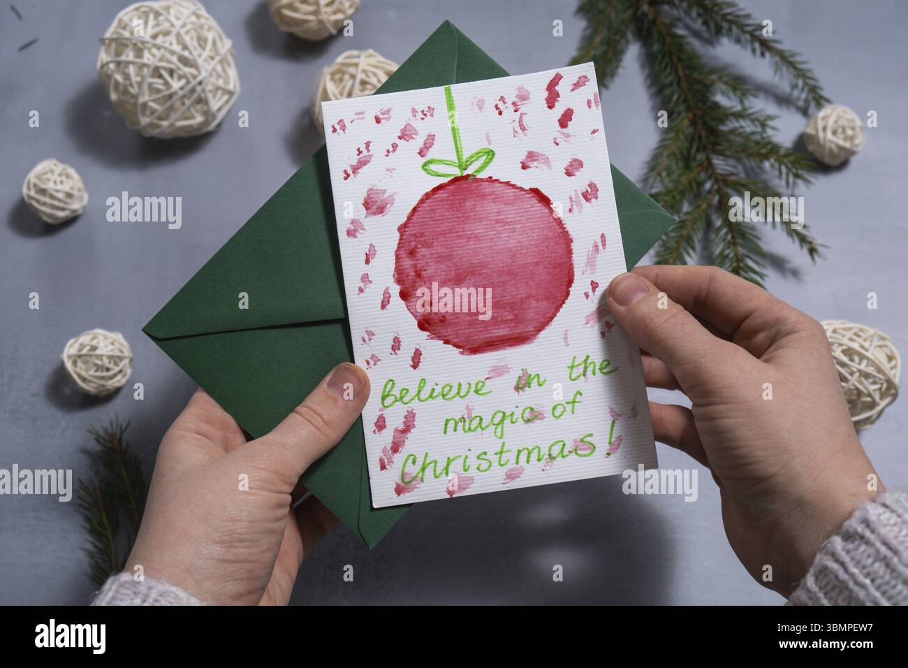 Palla di Natale preparazione natalizia sostenibile donna che tiene a mano biglietti di auguri fatti a mano con busta. Vacanza inclusiva e responsabile. Conscio Foto Stock