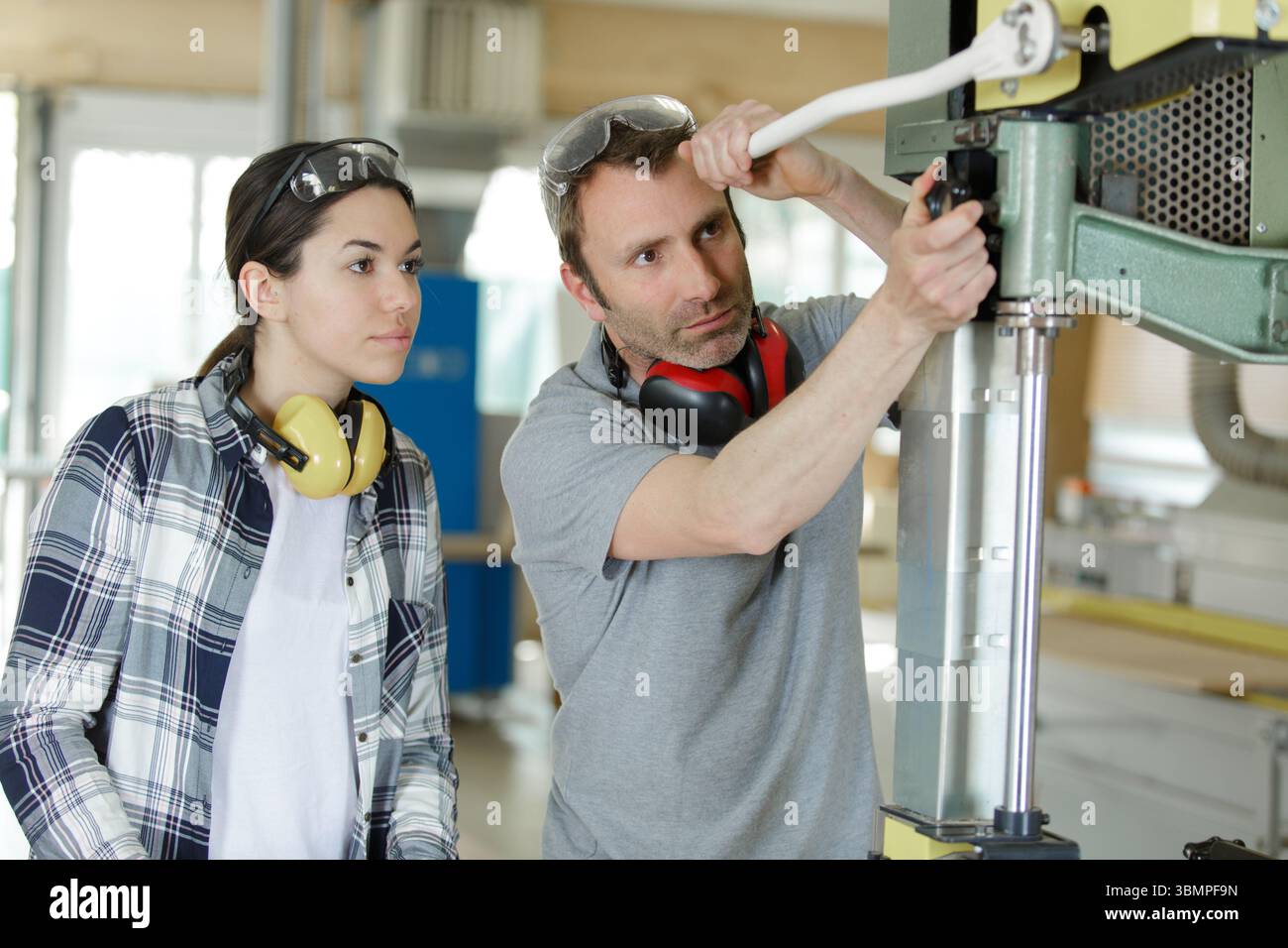 macchina operatrice per falegname femminile in una moderna officina per la lavorazione del legno Foto Stock