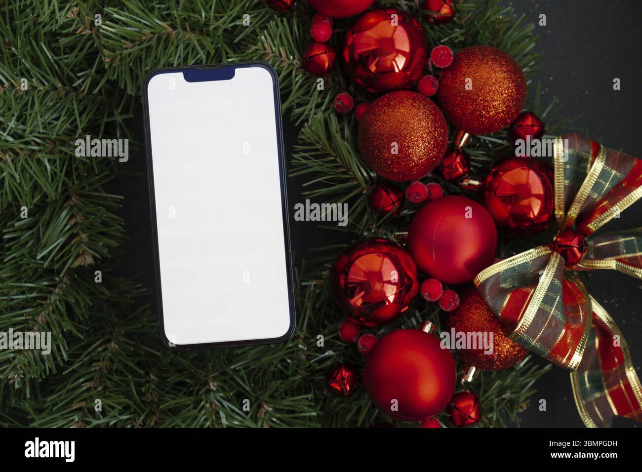 Corona di Natale fatta a mano con decorazioni natalizie con spazio per le copie del telefono su schermo bianco modello ADD sito Web. Festeggiamenti per le vacanze invernali Foto Stock