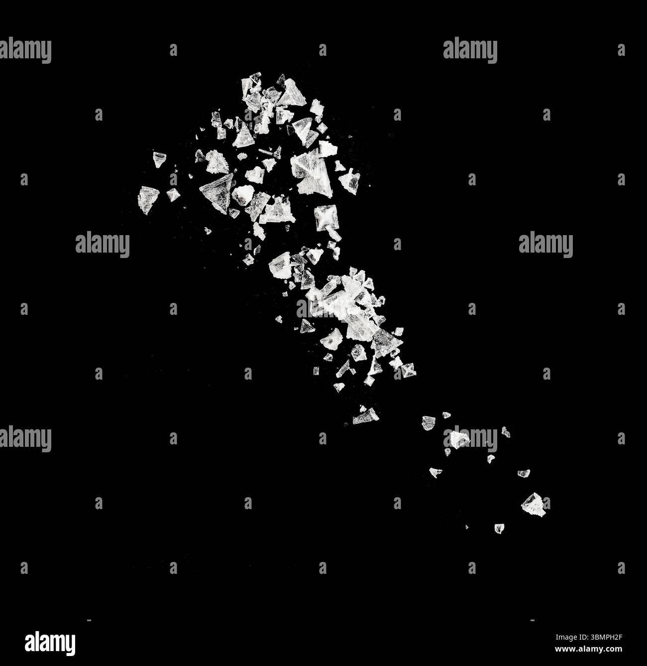 Primo piano di cristalli di sale cadenti isolati sul nero come consistenza Foto Stock