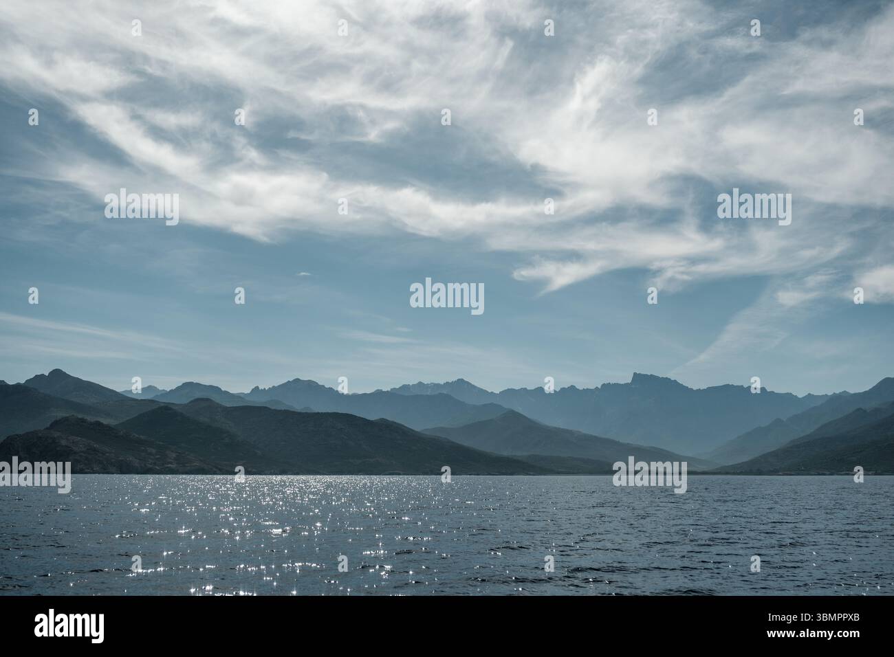 La costa occidentale frastagliata della Corsica e la montagna paglia Orba, vista verso il Mar Mediterraneo con nuvole di neve Foto Stock