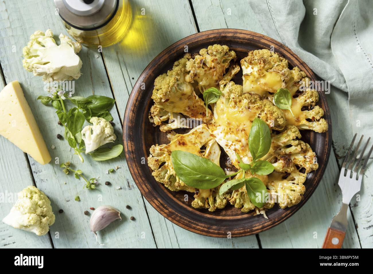 Cibo biologico vegetariano. Bistecche di cavolfiore al forno con erbe e spezie su un tavolo di legno. Alimentazione sana, concetto di sostituto della carne a base vegetale. Vista f Foto Stock