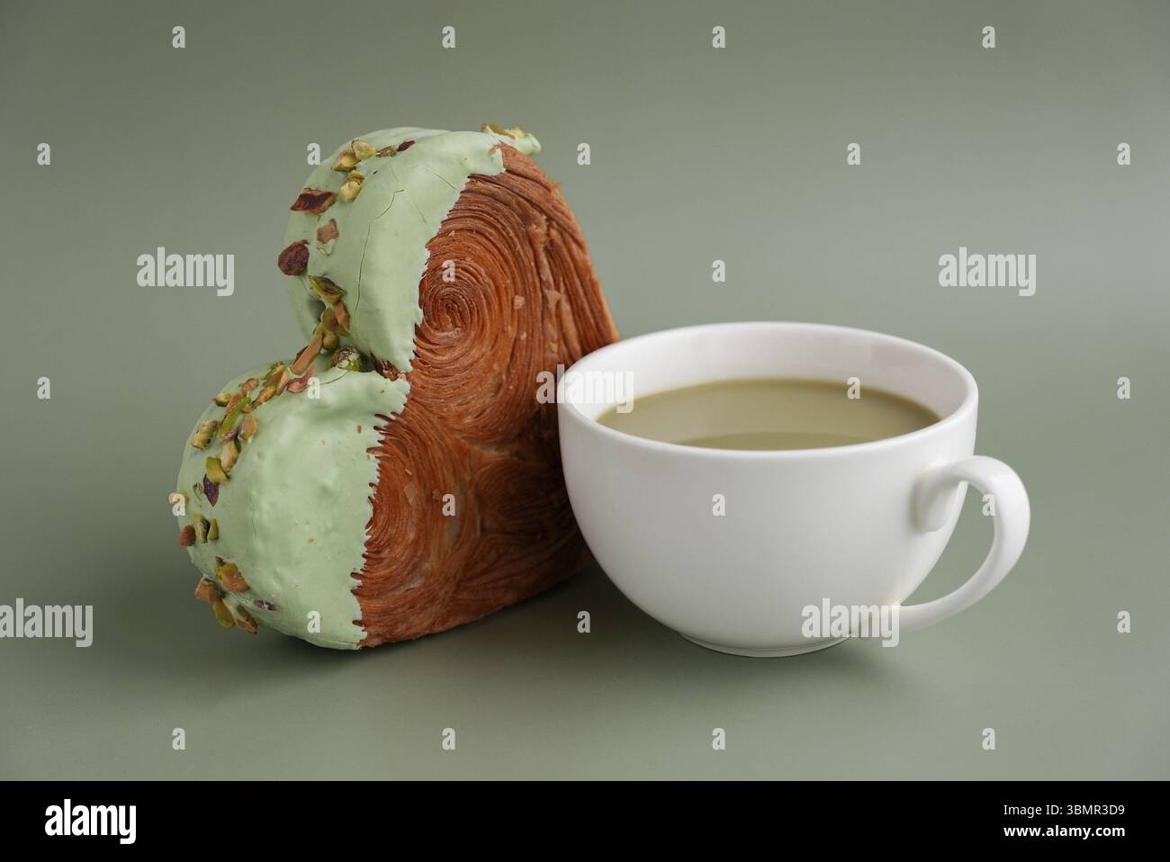 Bevanda bevanda caffè cappuccino latte delizioso croissant fresco condito con tè verde Matcha Ganache. Creazione di una panetteria a forma di cuore unica. Puff Foto Stock