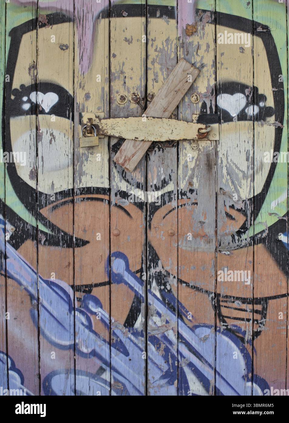 Lucchetto che fissa la porta in legno con graffiti e cuori di cartoni animati Foto Stock