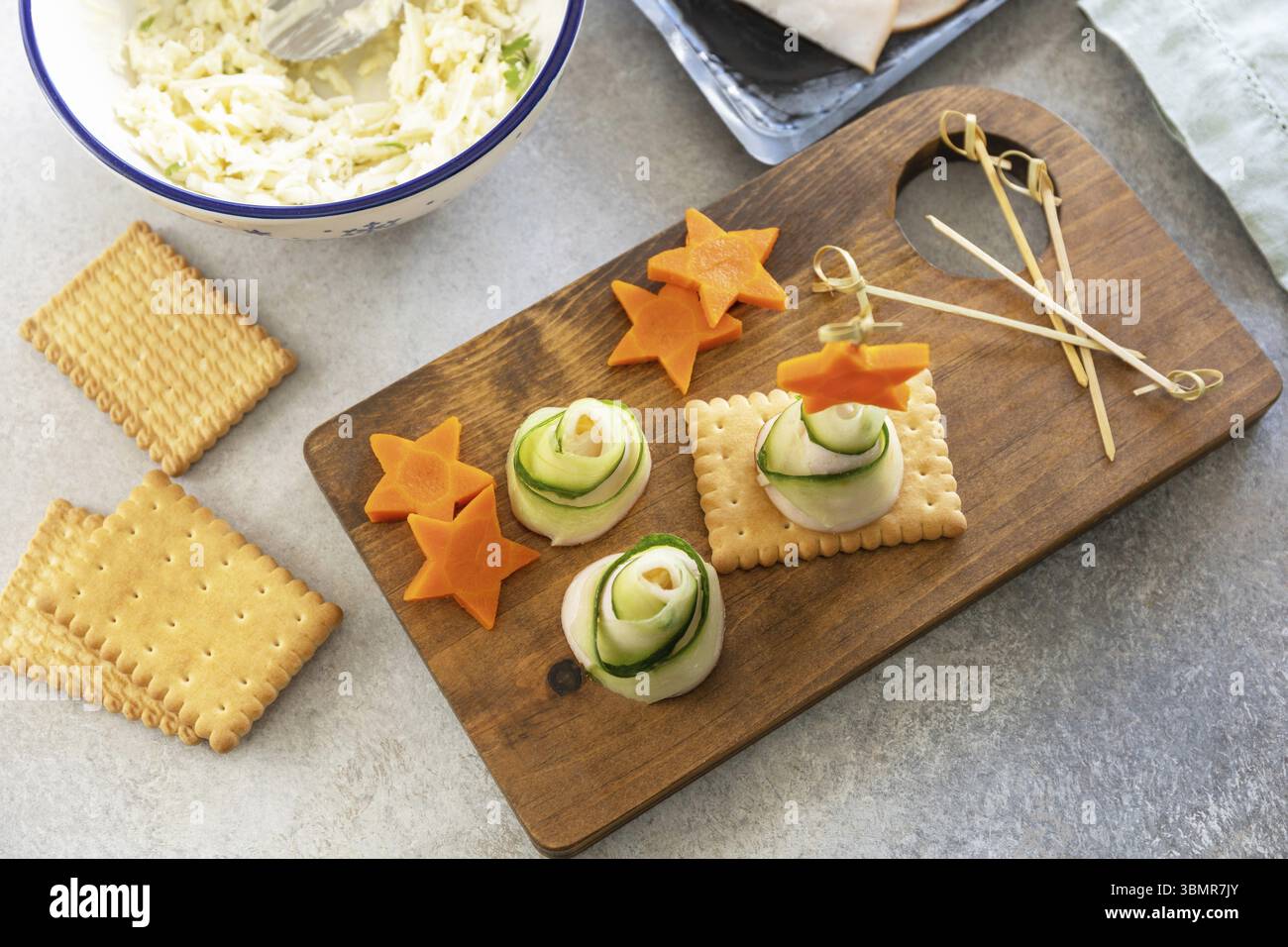 Cucinare alberi di Natale di prosciutto, cetriolo, formaggio e stella di carota sui cracker, passo dopo passo, punto 4 Foto Stock