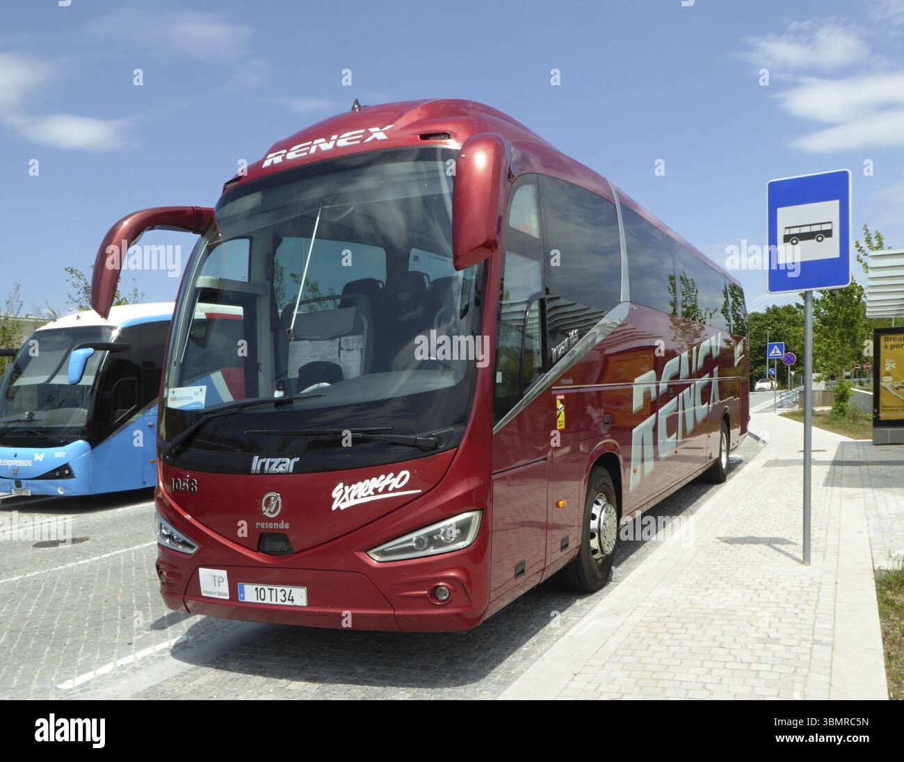 Autobus rosso Renex Irizar i8 parcheggiato alla fermata dell'autobus, pronto per il trasporto passeggeri Foto Stock
