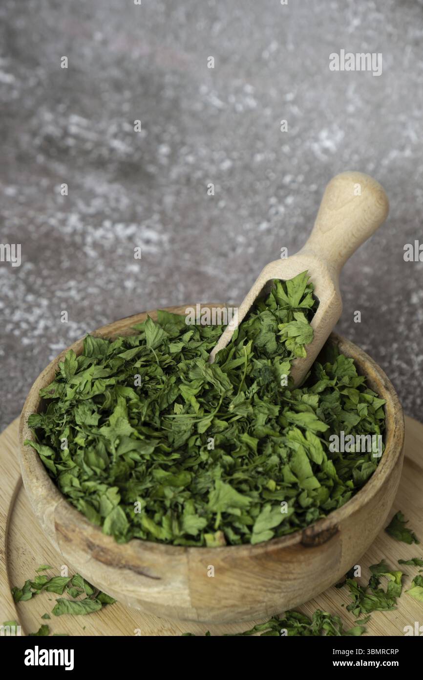 Recipiente in legno con prezzemolo verde secco. Vegetariano bio insalata biologica erba mangiare sano. Casa giardino immunità-Boosting erbe. Raccolto stagionale cottagecor Foto Stock