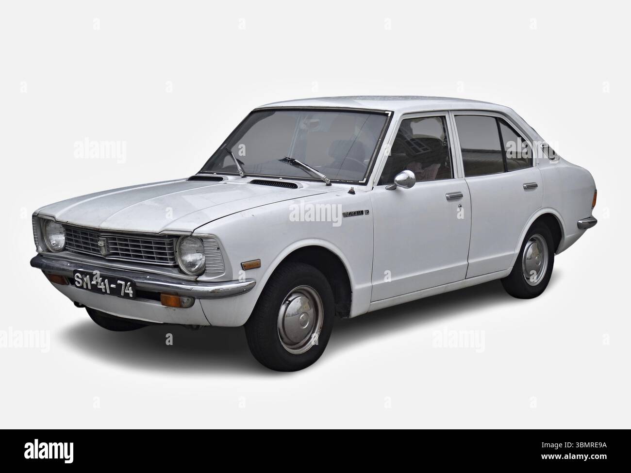 Classica Toyota Corolla bianca parcheggiata su uno sfondo bianco, che mostra il suo fascino vintage Foto Stock