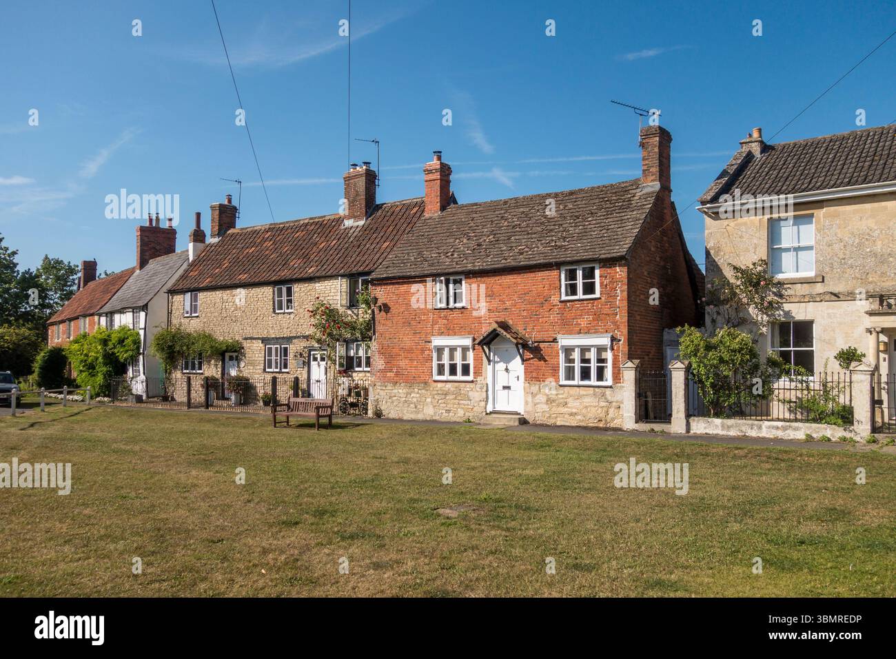 Vecchie case sul verde del villaggio nel centro di Steeple Ashton, Wiltshire, Regno Unito Foto Stock
