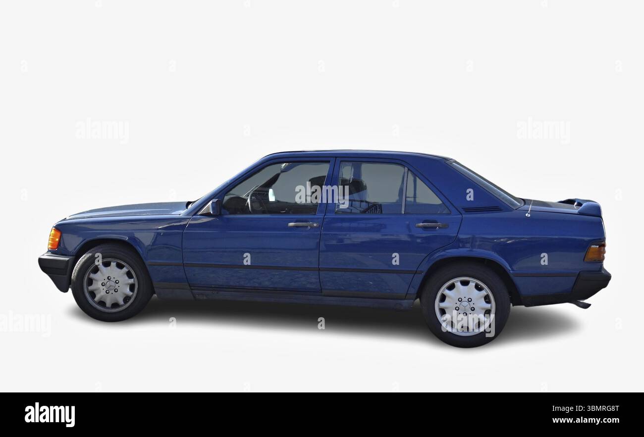 La classica berlina blu Mercedes-Benz 190E parcheggiata su sfondo bianco, presenta un design senza tempo Foto Stock