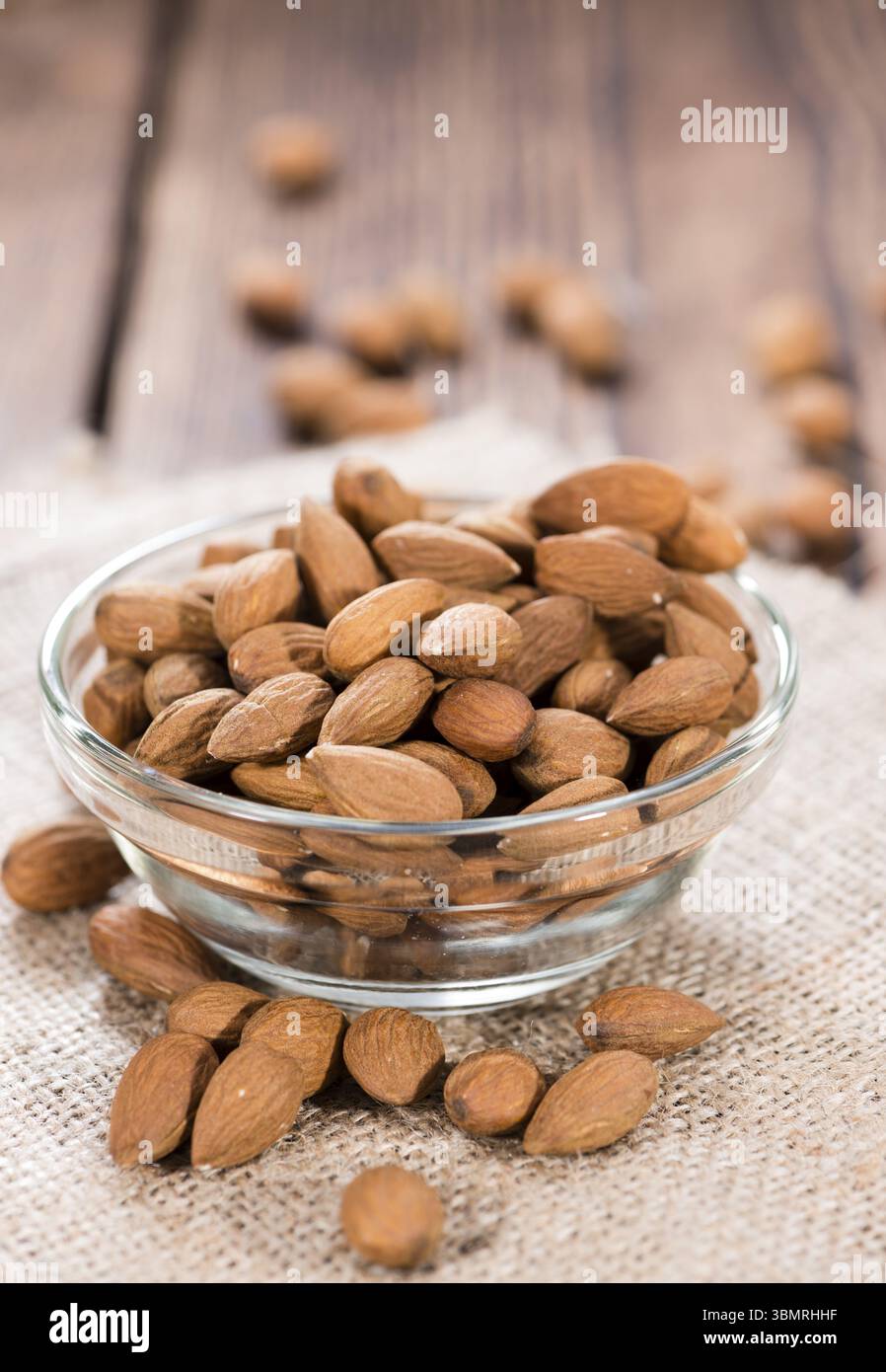 Mandorle (dettagliate di close-up shot) su sfondo di legno Foto Stock