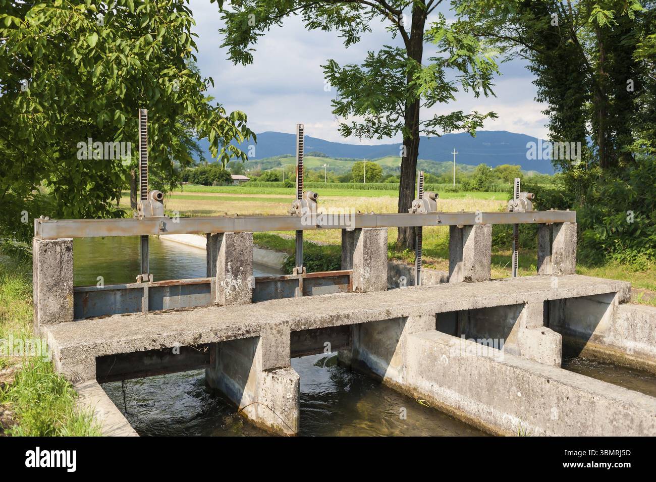 Installazione di chiuse sul fiume per deviare l'acqua in vari canali di irrigazione per l'agricoltura Foto Stock