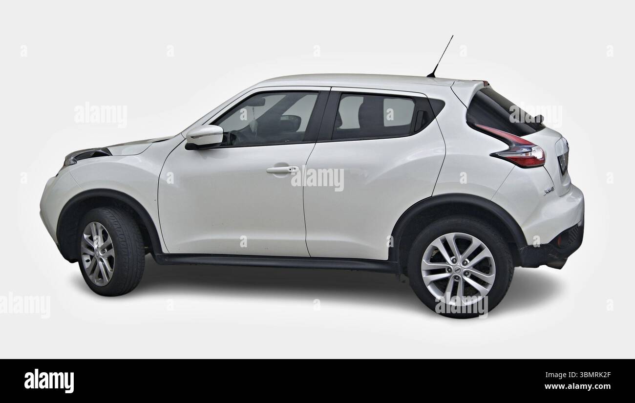 Vista laterale di una Nissan Juke bianca parcheggiata su uno sfondo bianco, che mostra il suo design moderno Foto Stock