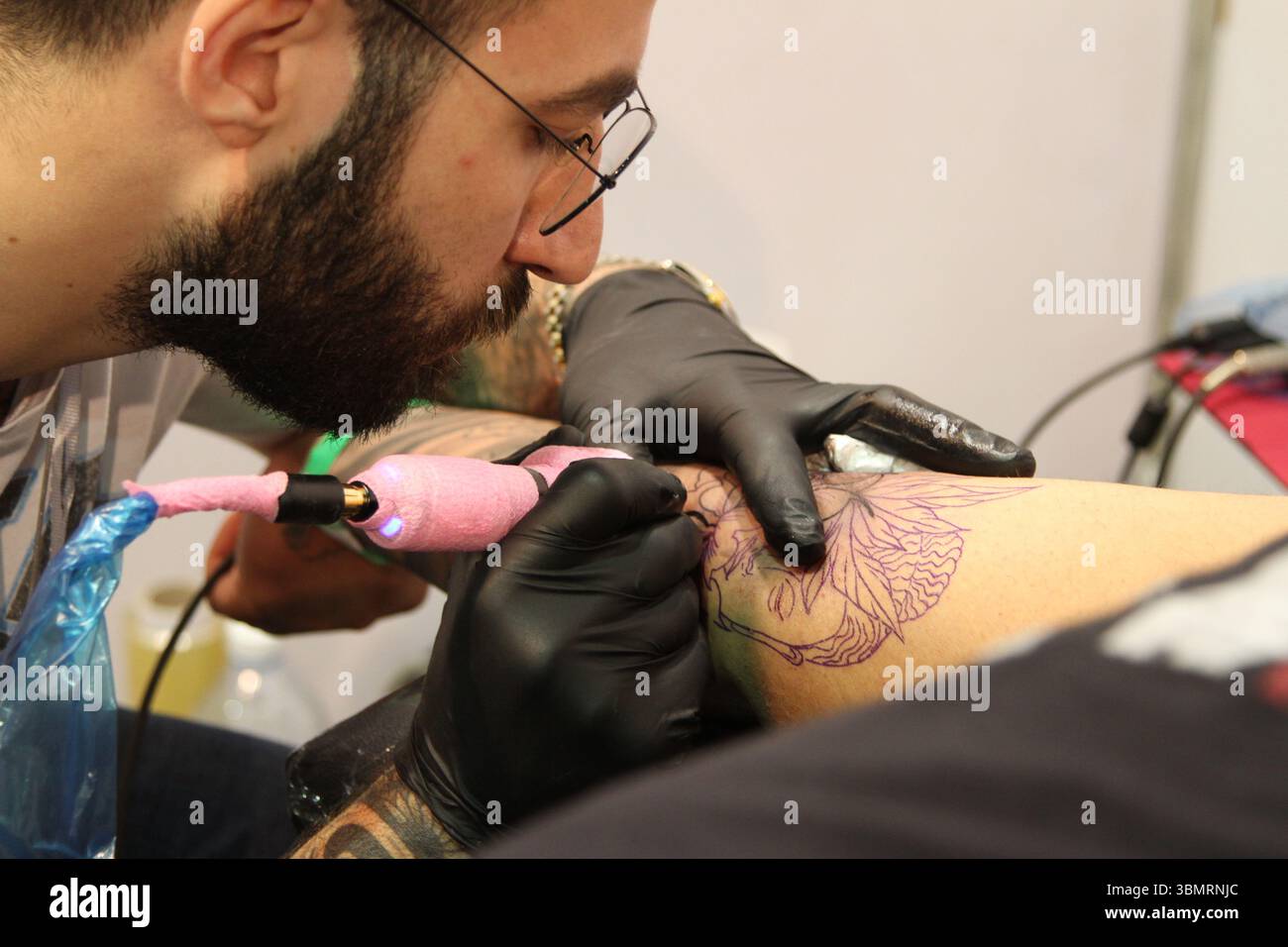 Servizio fotografico in stile documentario per catturare il processo di tatuaggio e i disegni Foto Stock